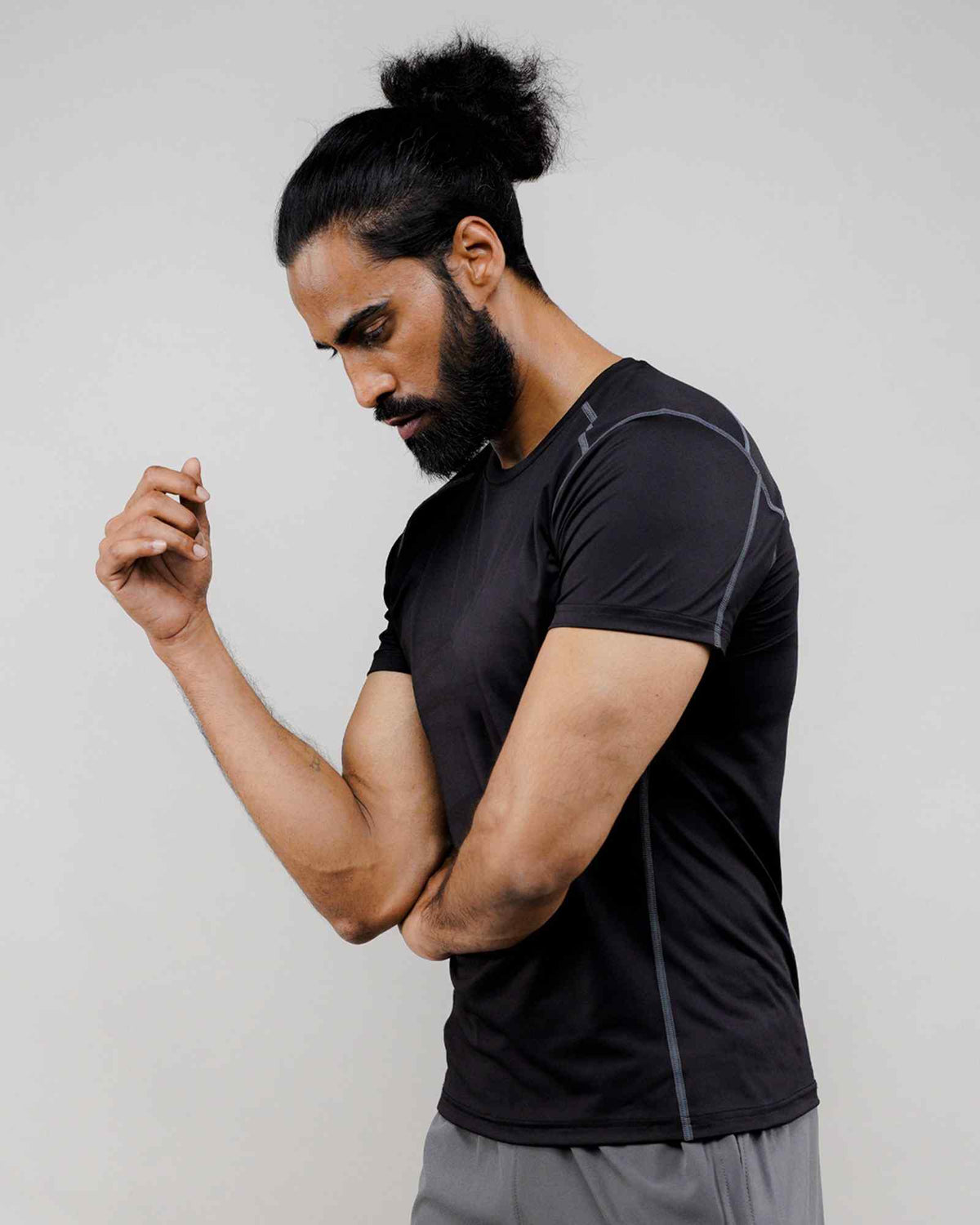 Men's black athletic compression T-shirt side view with gray contrast seams, short sleeve.