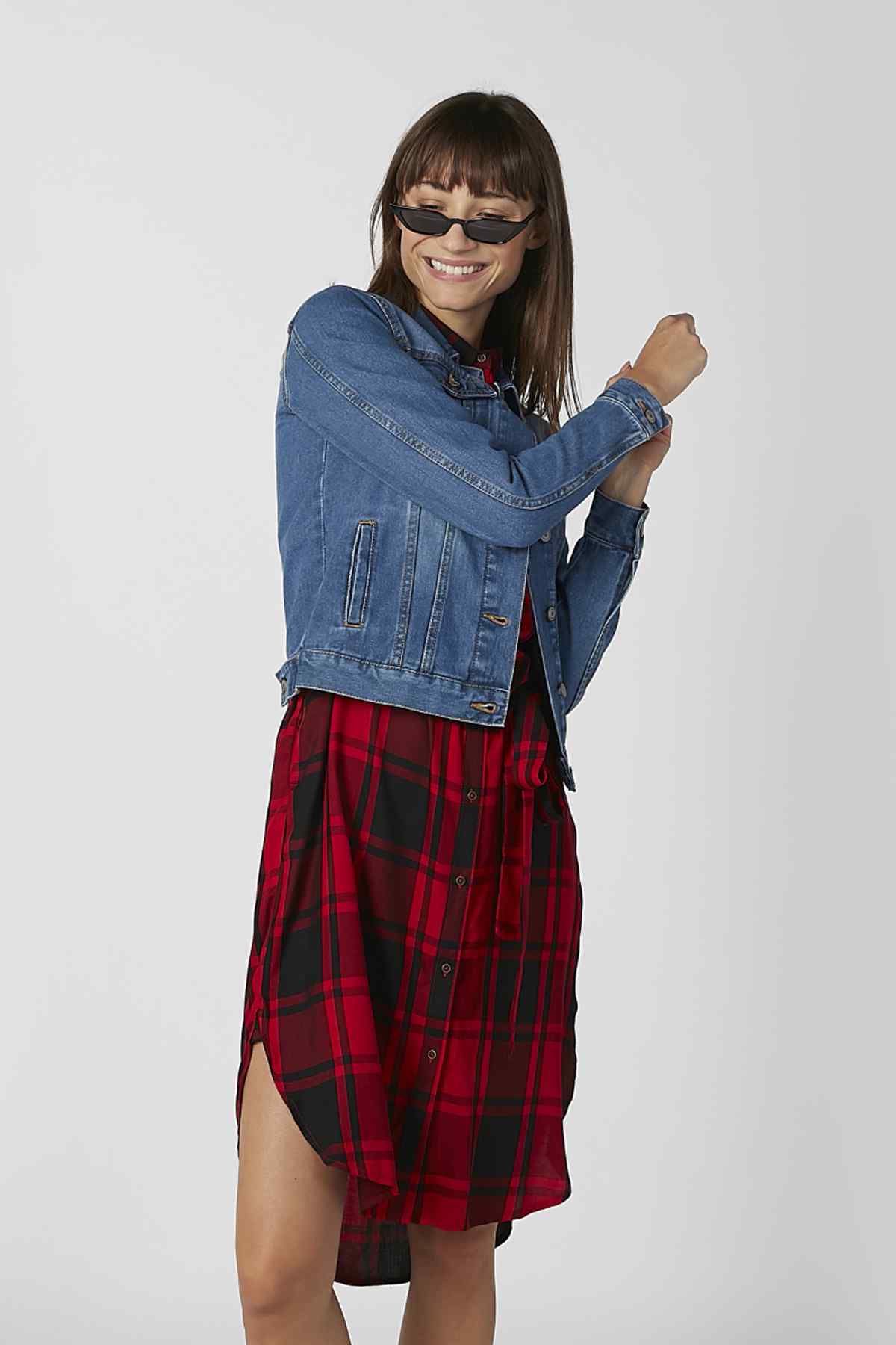 Blue denim jacket with buttoned cuffs and chest pockets, plaid shirt visible