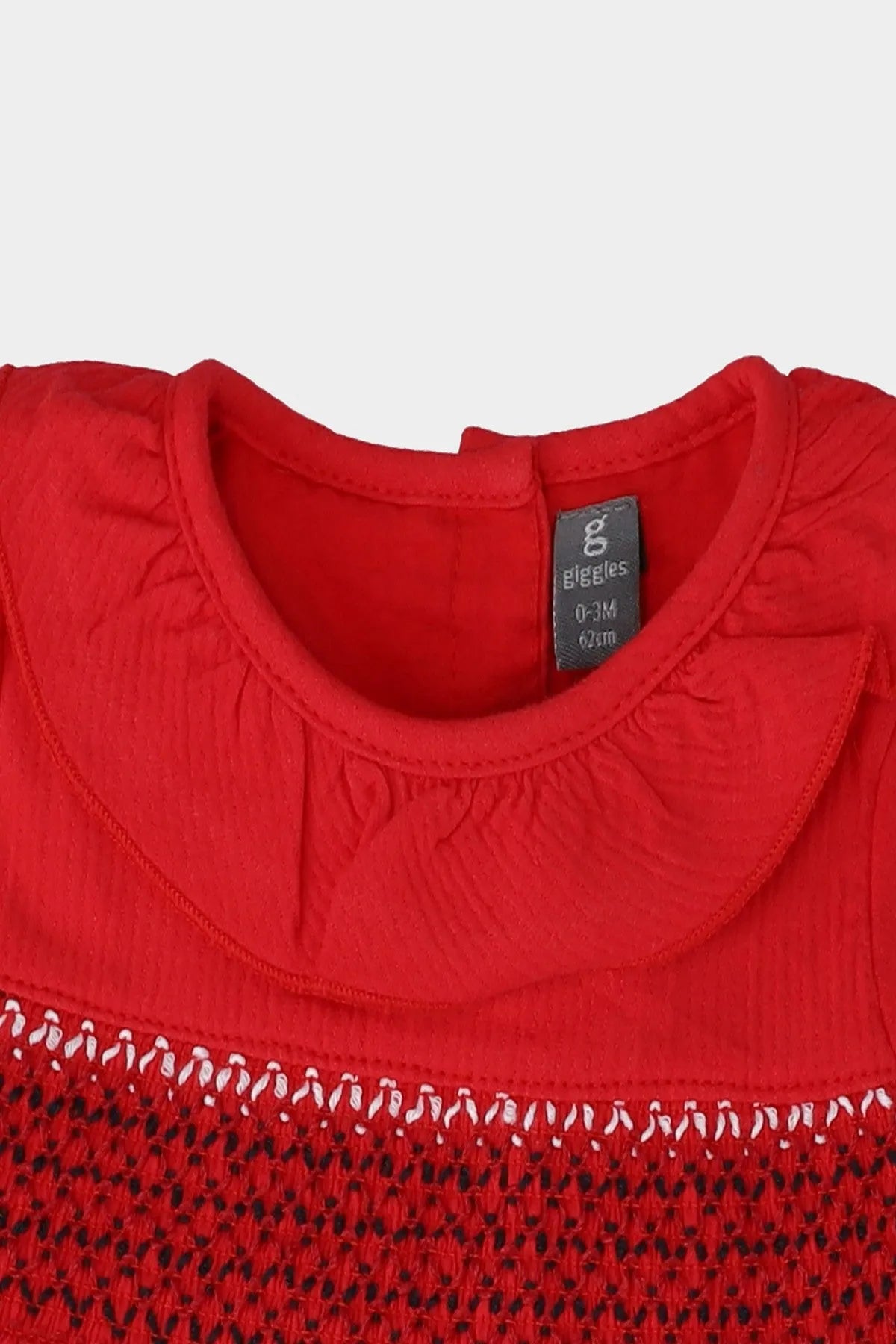 Red baby dress close-up: ribbed collar and smocked yoke