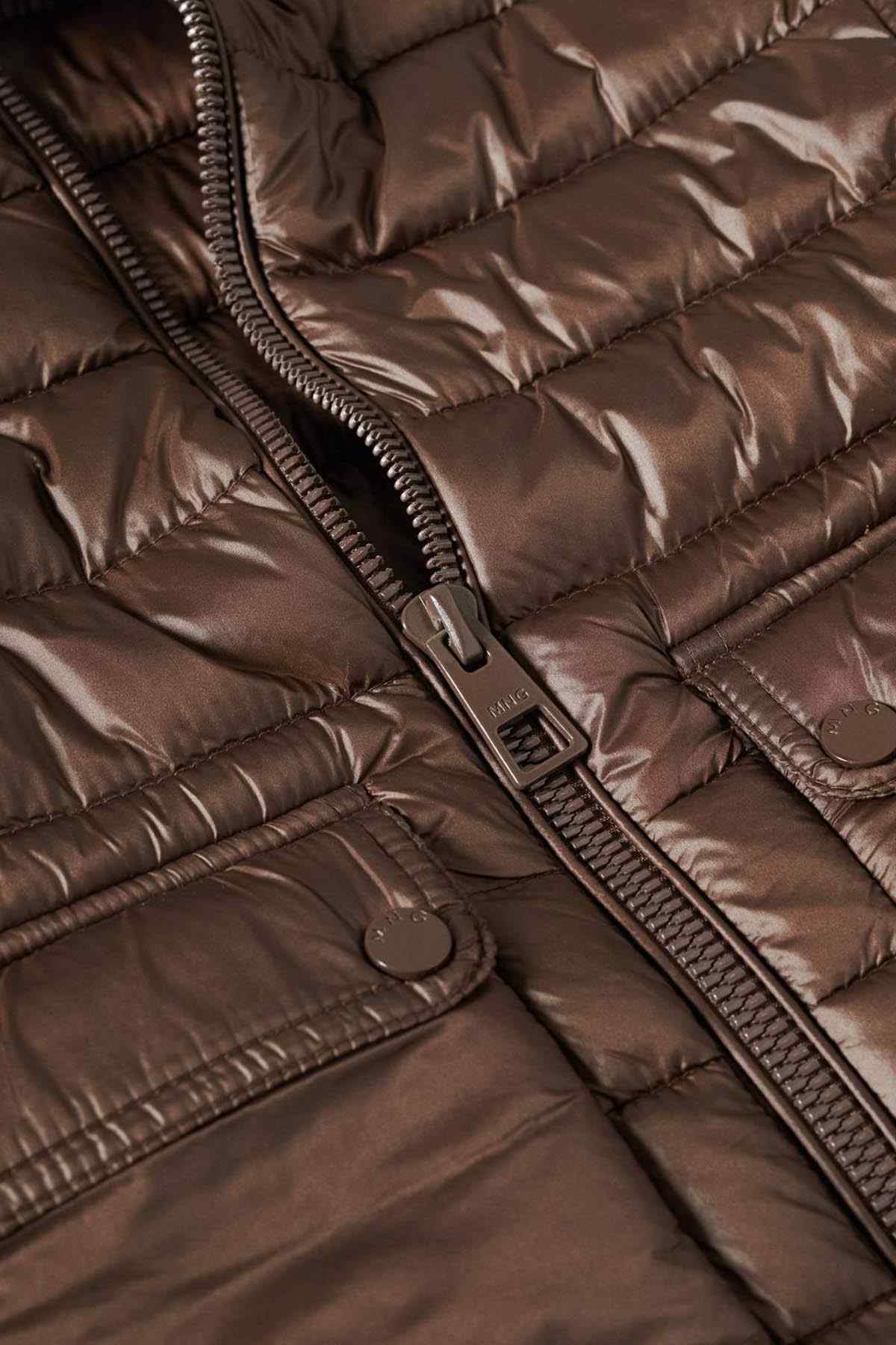 Brown puffer jacket close-up of zip pull, zipper track, and logo patch