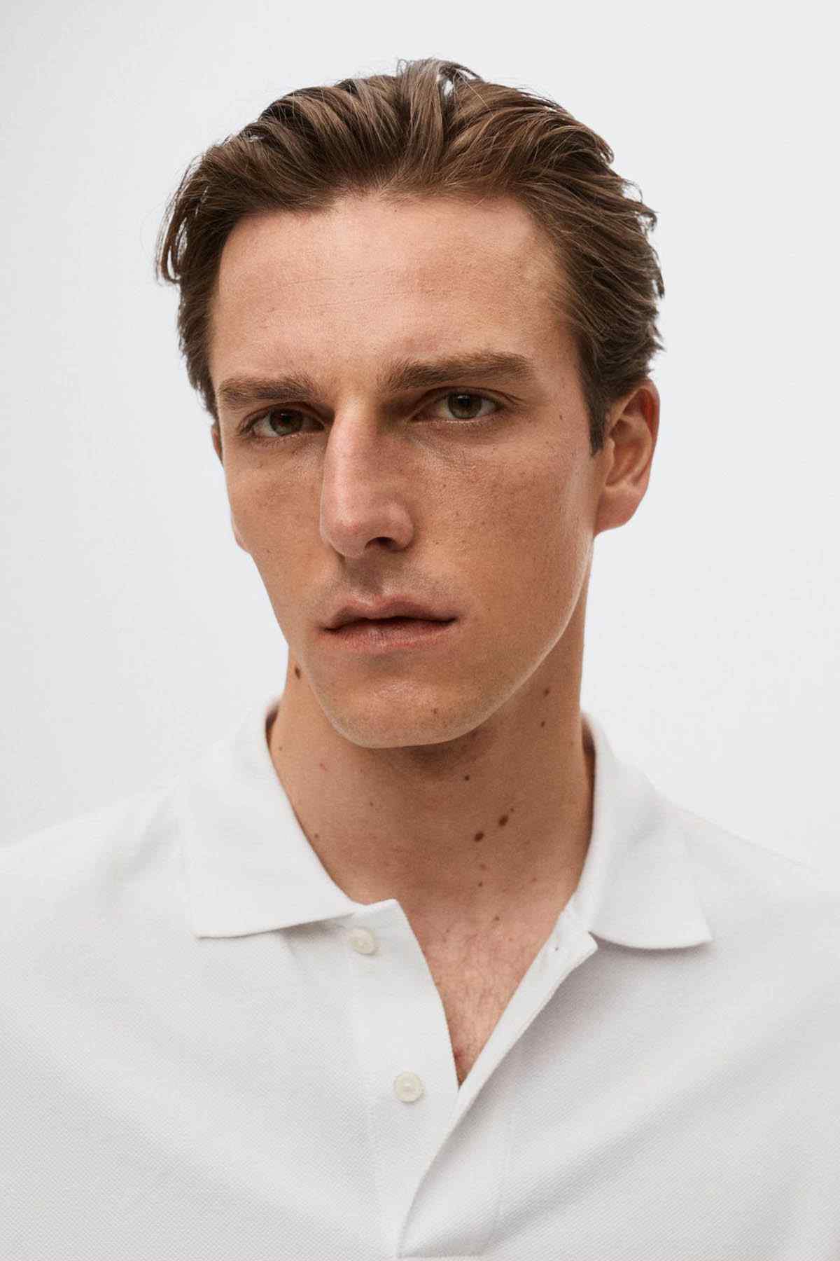 Close-up of white polo shirt collar and button placket, short sleeves