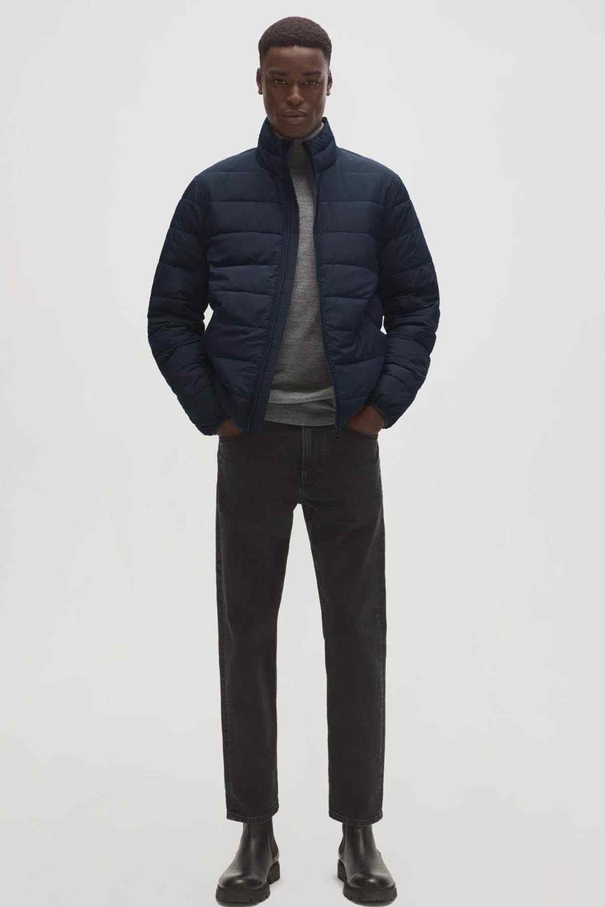MANGO men's navy quilted puffer jacket worn with neutral shirt and dark pants