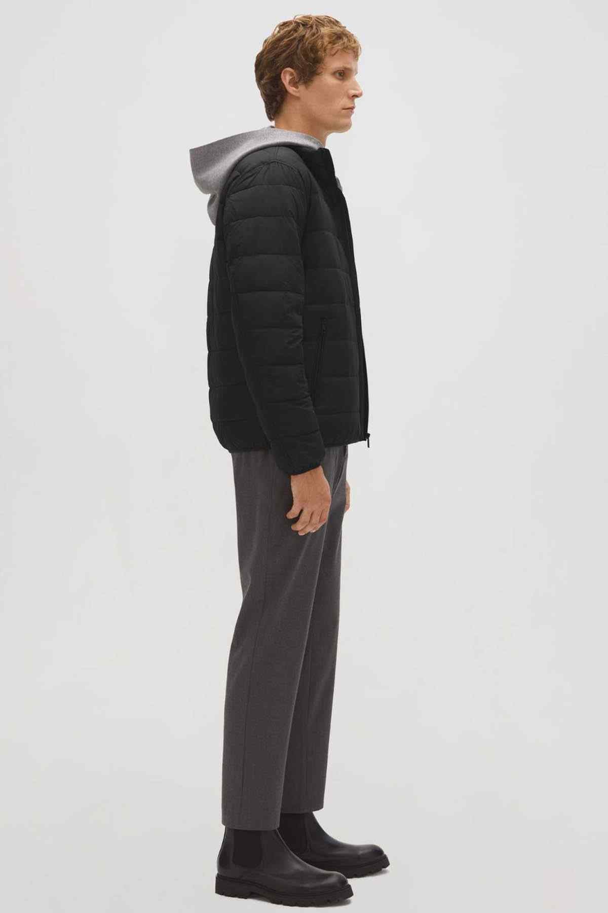 Black quilted puffer jacket on model, side profile