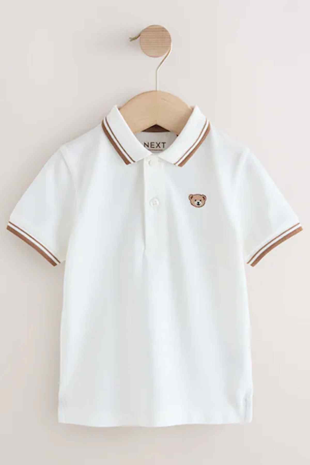 Children's white polo shirt front view with brown-striped collar and teddy bear patch