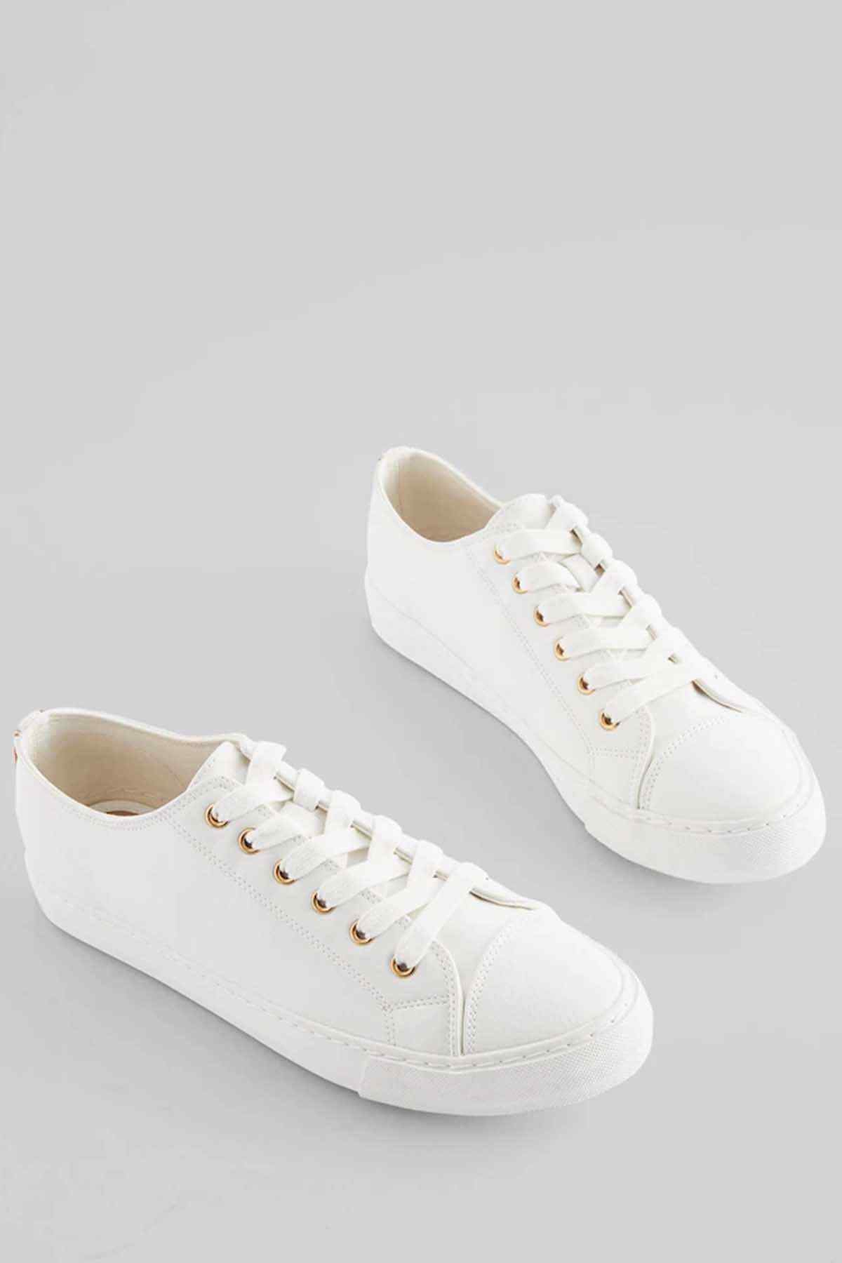 White sneakers for both feet, lace-up front with gold-tone eyelets.