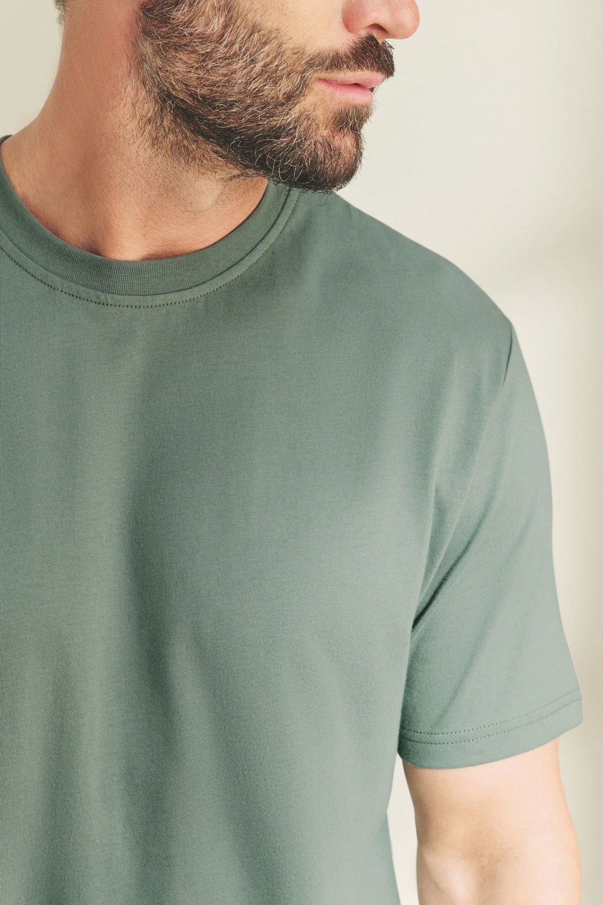 Green short-sleeve crewneck T-shirt, smooth fabric and stitched neckline.