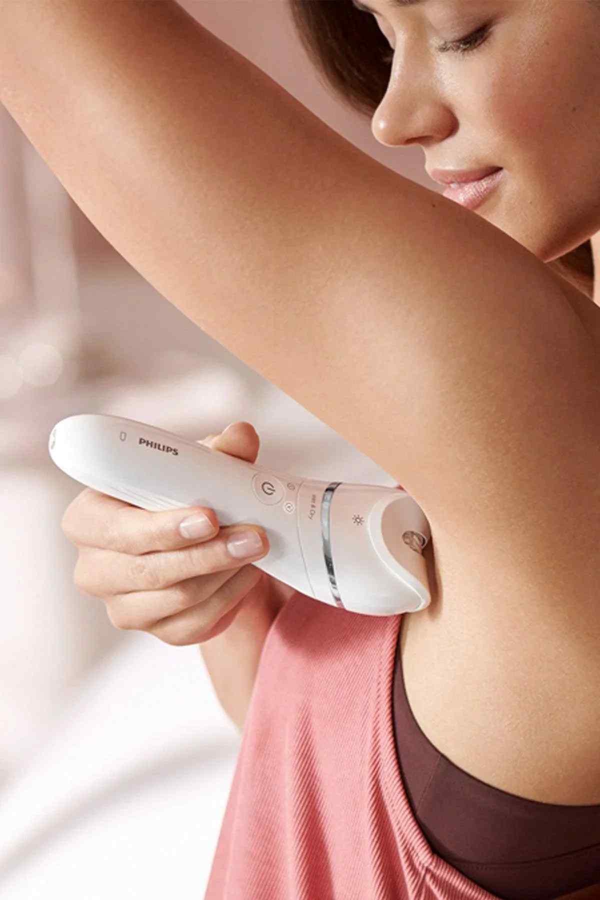 White epilator gliding over leg skin for hair removal