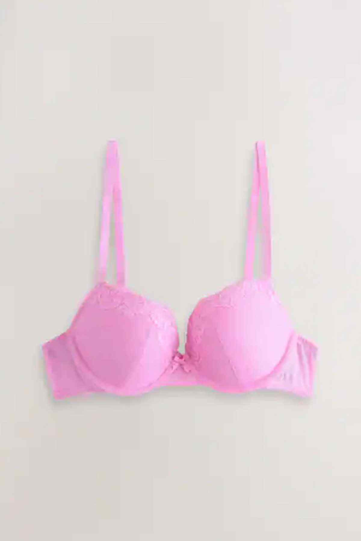 Pair of pink underwire bras with lace cups and adjustable straps