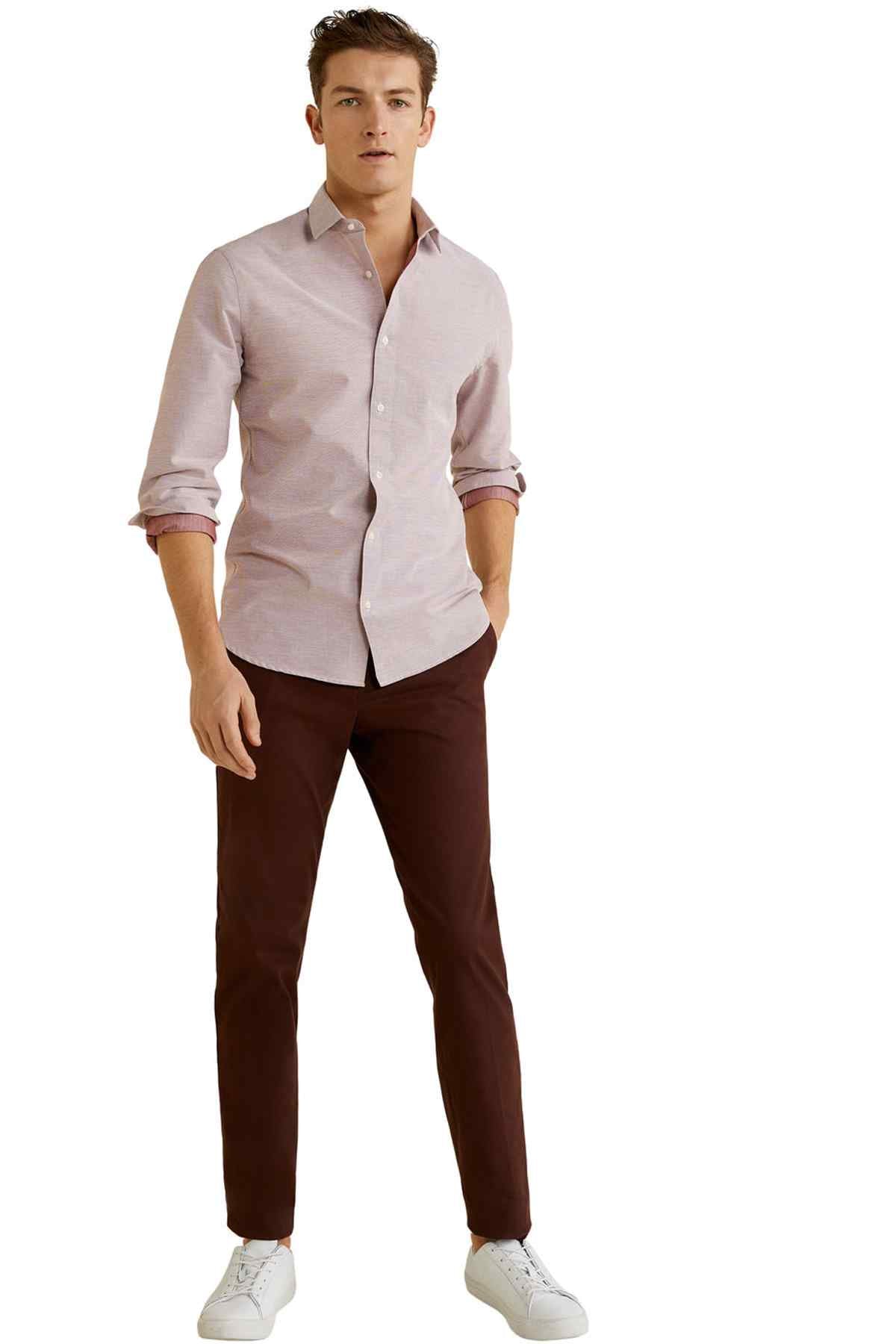 Men's light pink button-up shirt with dark brown trousers and long sleeves