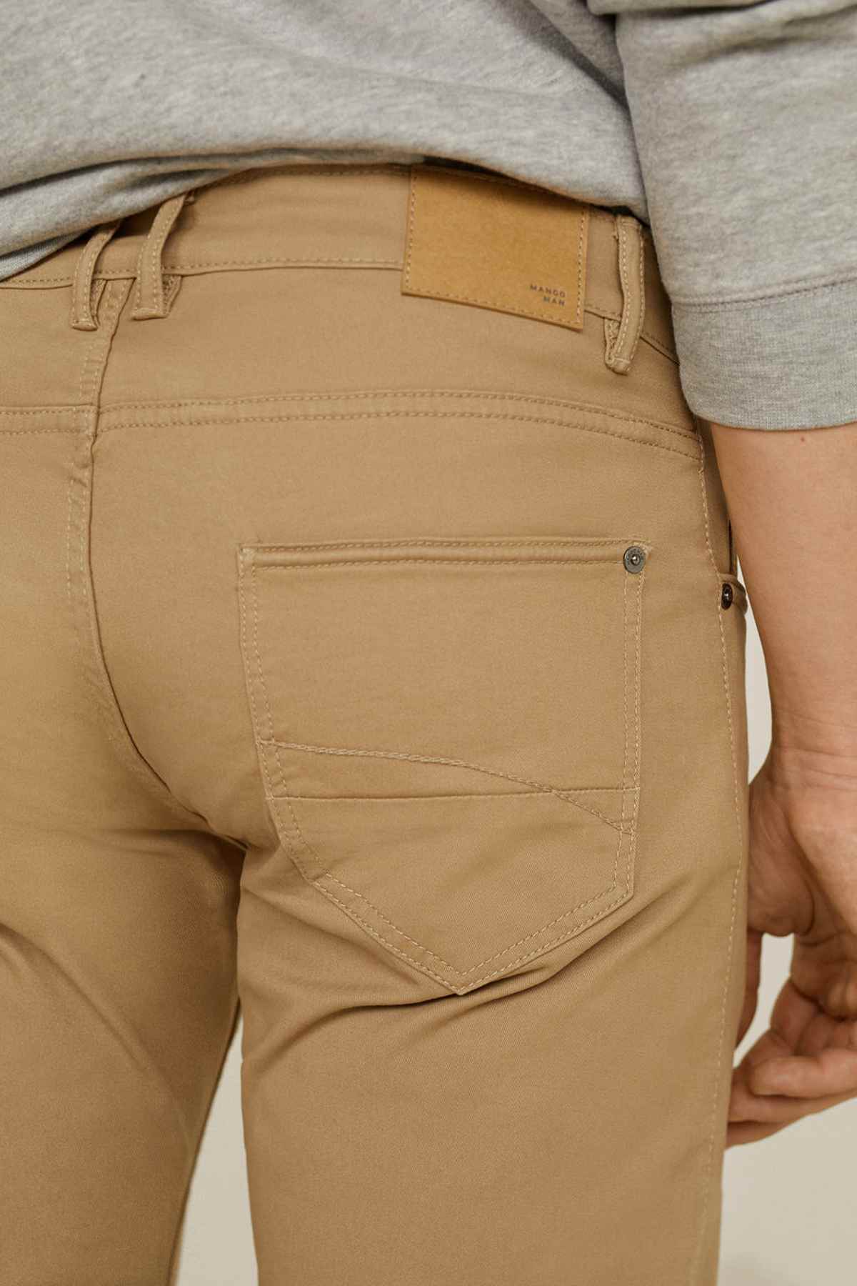 Men's tan chinos close-up of back pocket and yoke stitching