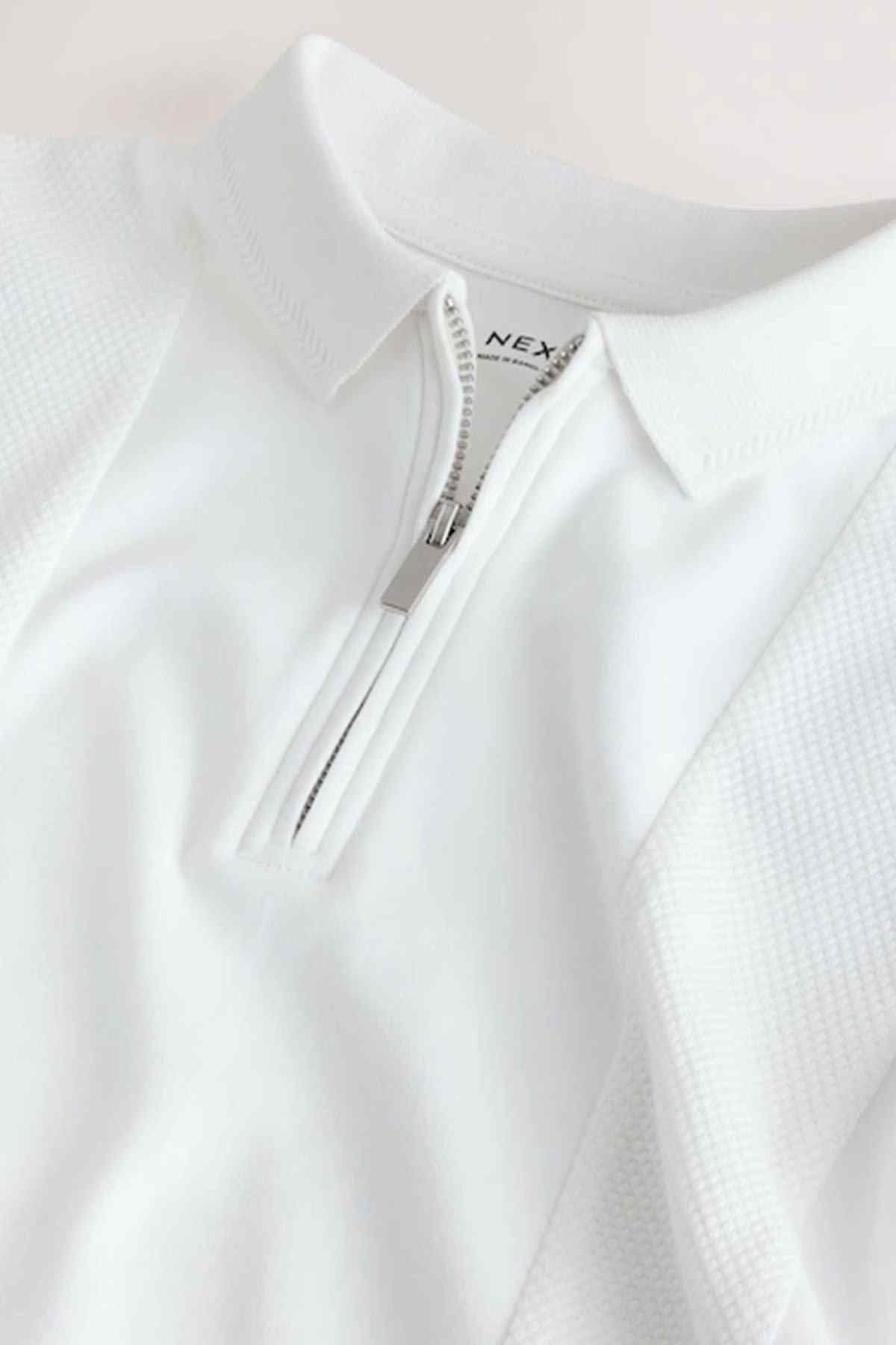 White zip polo shirt collar detail with NEXT logo and front zip