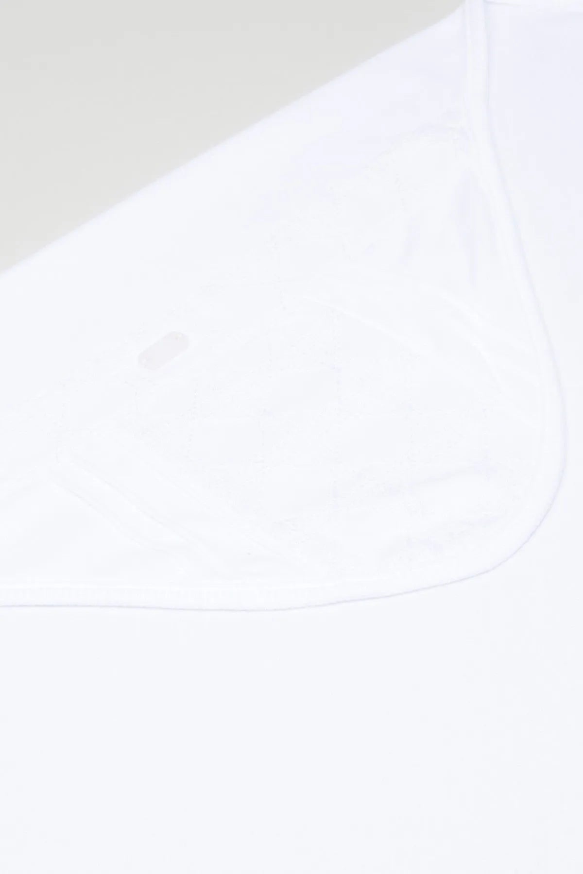 White baby blanket fabric close-up with curved stitched edge