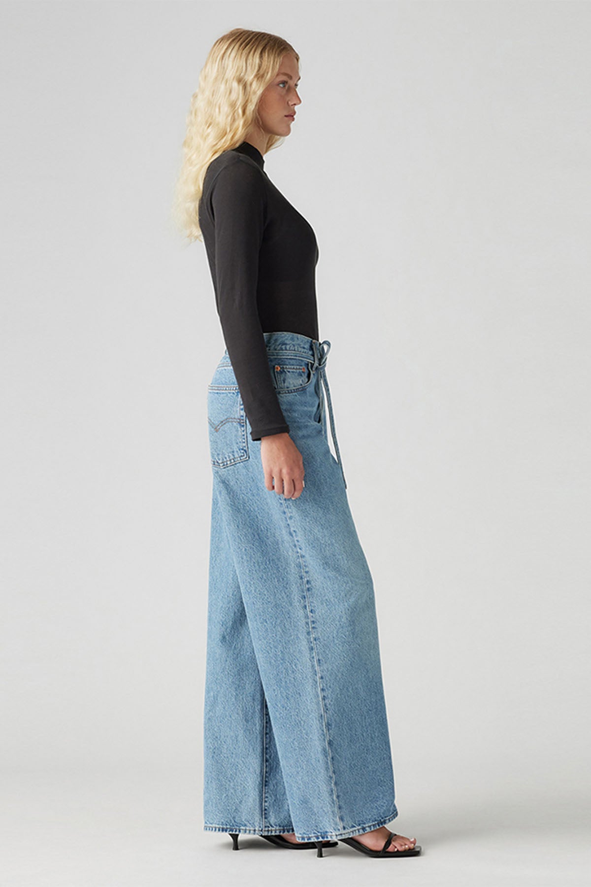 Blue denim jeans with wide-leg fit, side view