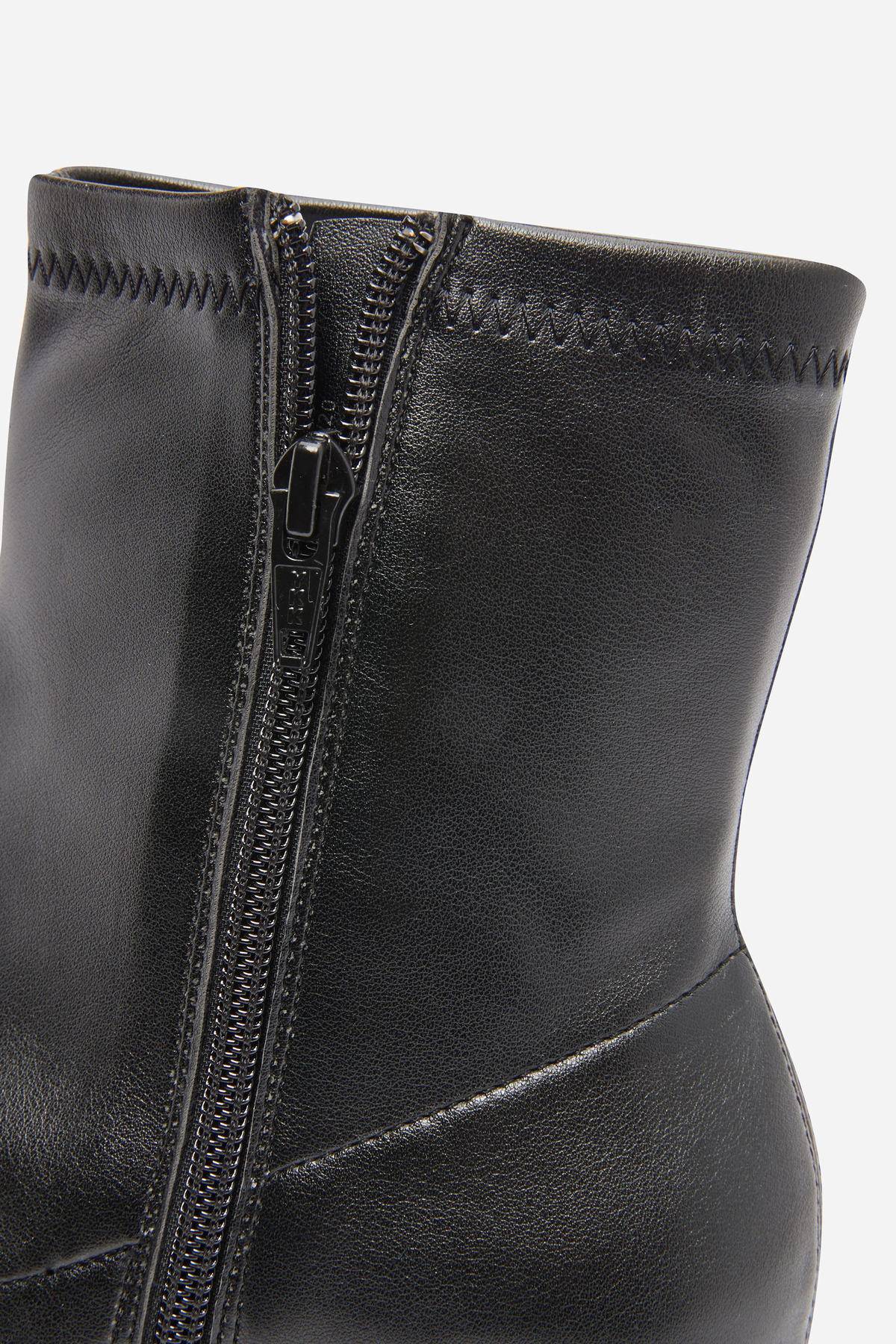 Black leather ankle boot upper with silver side zipper close-up