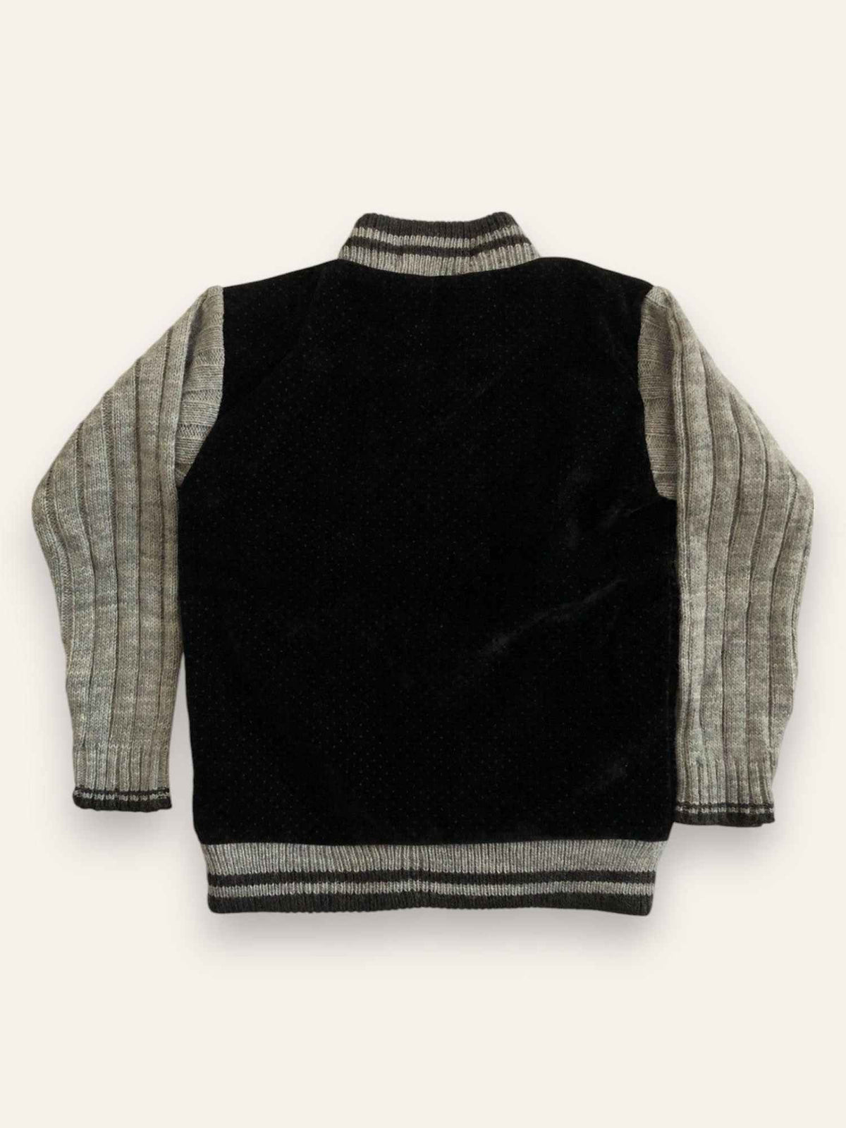 Two-tone varsity jacket back view, black body with grey striped sleeves and ribbed hem