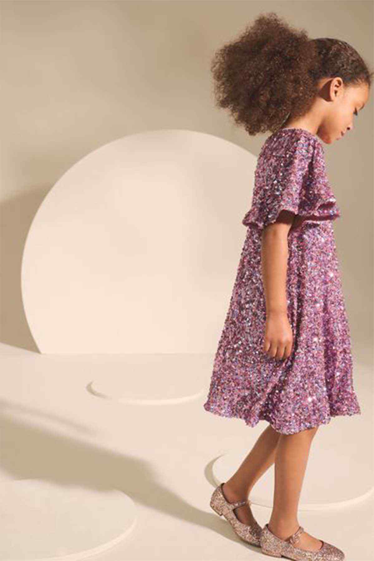 Girls' pink sparkly dress, side view, short flutter sleeves and gathered skirt