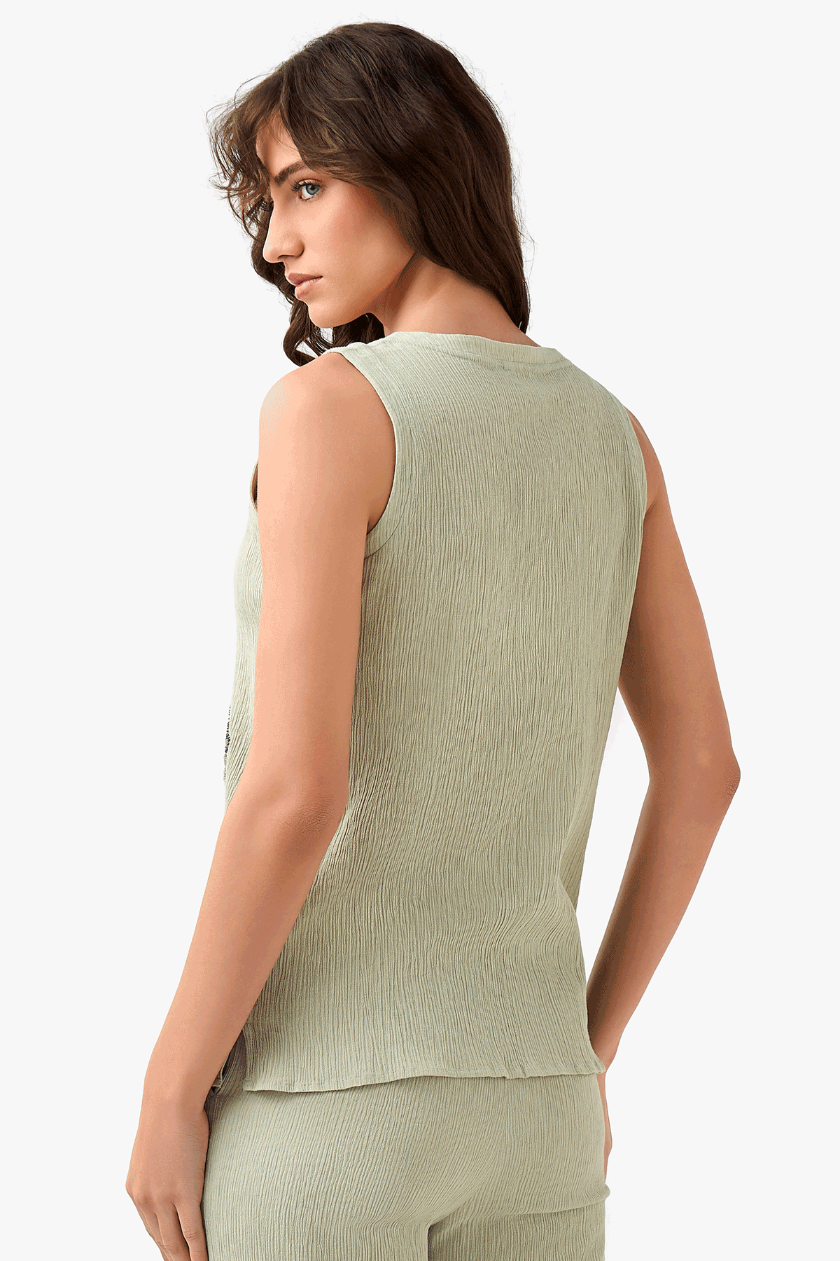 Light green sleeveless top back view with textured fabric and embroidered motifs