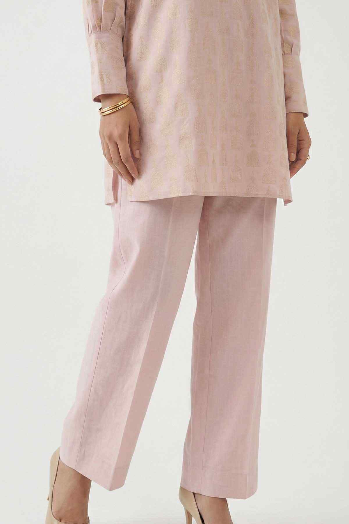 Light pink straight-leg pants with cuffed hem, close-up