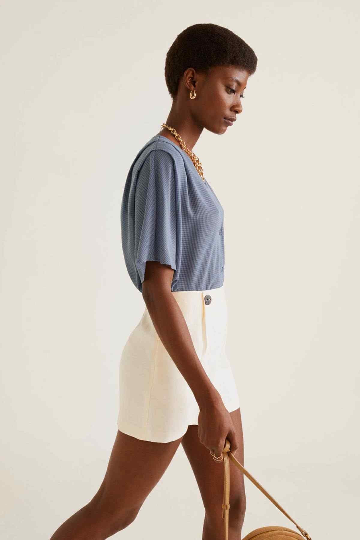 Light blue short-sleeve V-neck blouse with button front, side view