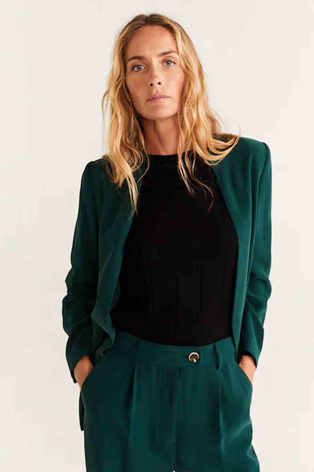 Green blazer with relaxed fit and high-waist trousers, gold waist button