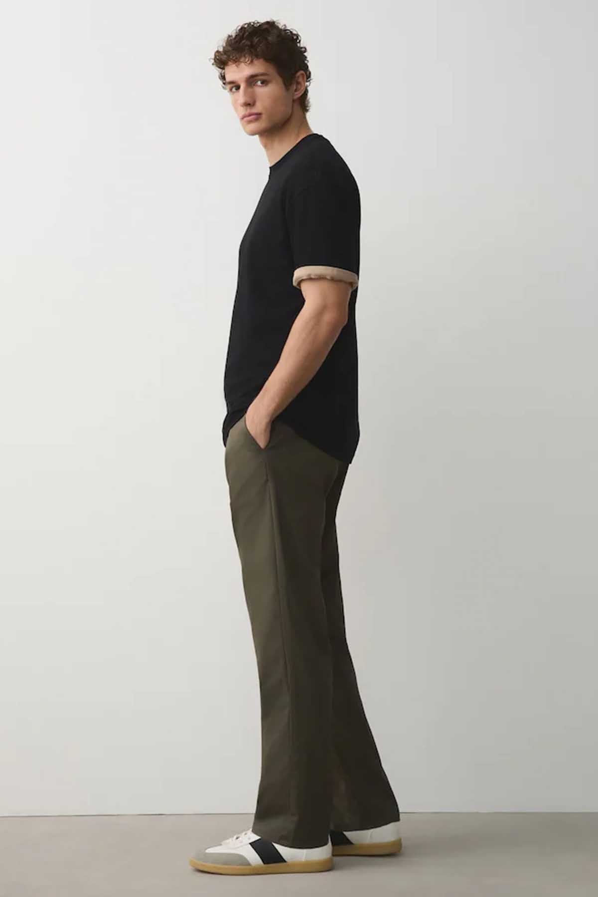 Men's khaki green straight-leg trousers with black short-sleeve T-shirt, side view