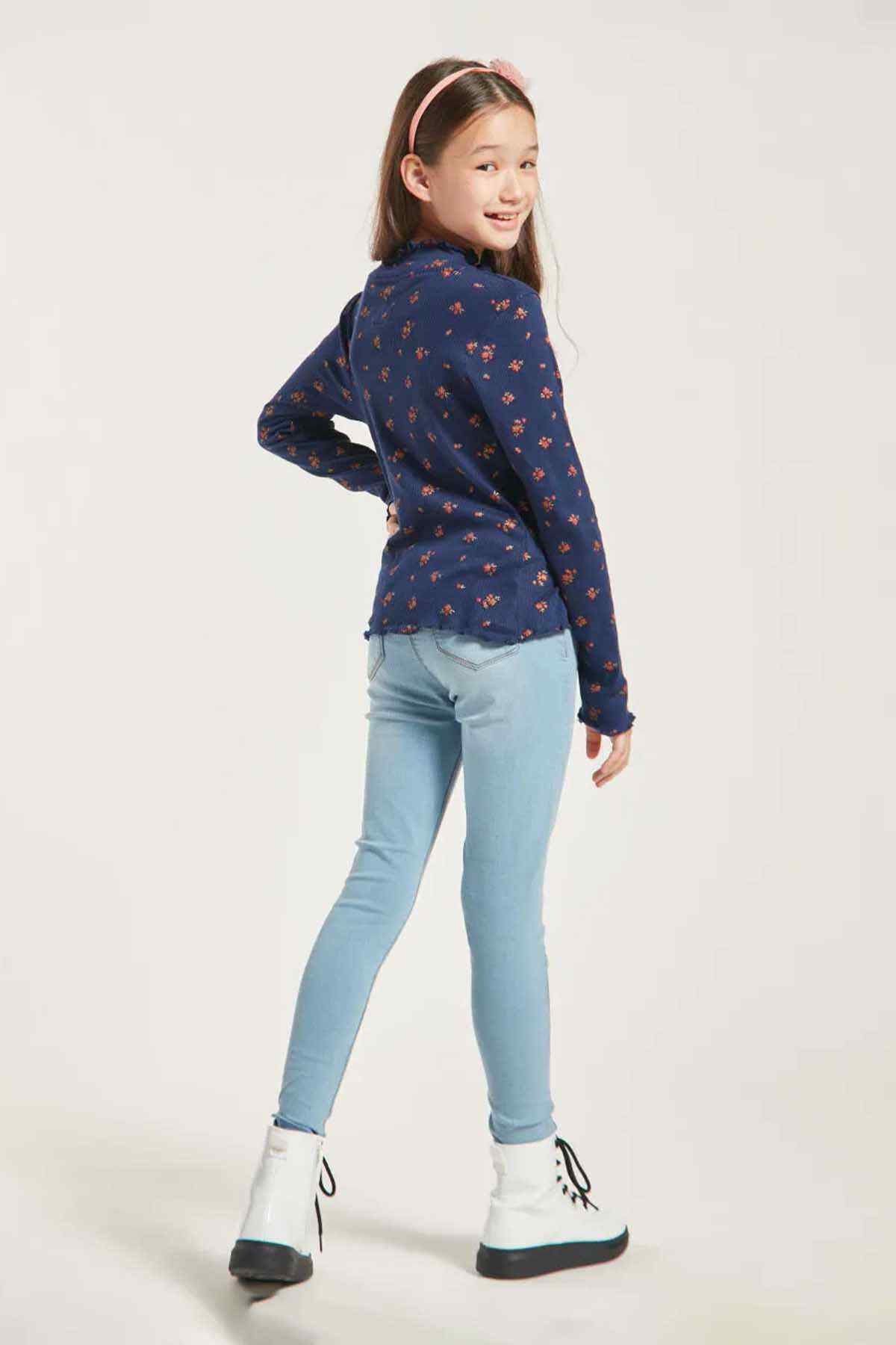 Girls navy long-sleeve patterned top with light-blue skinny jeans and boots