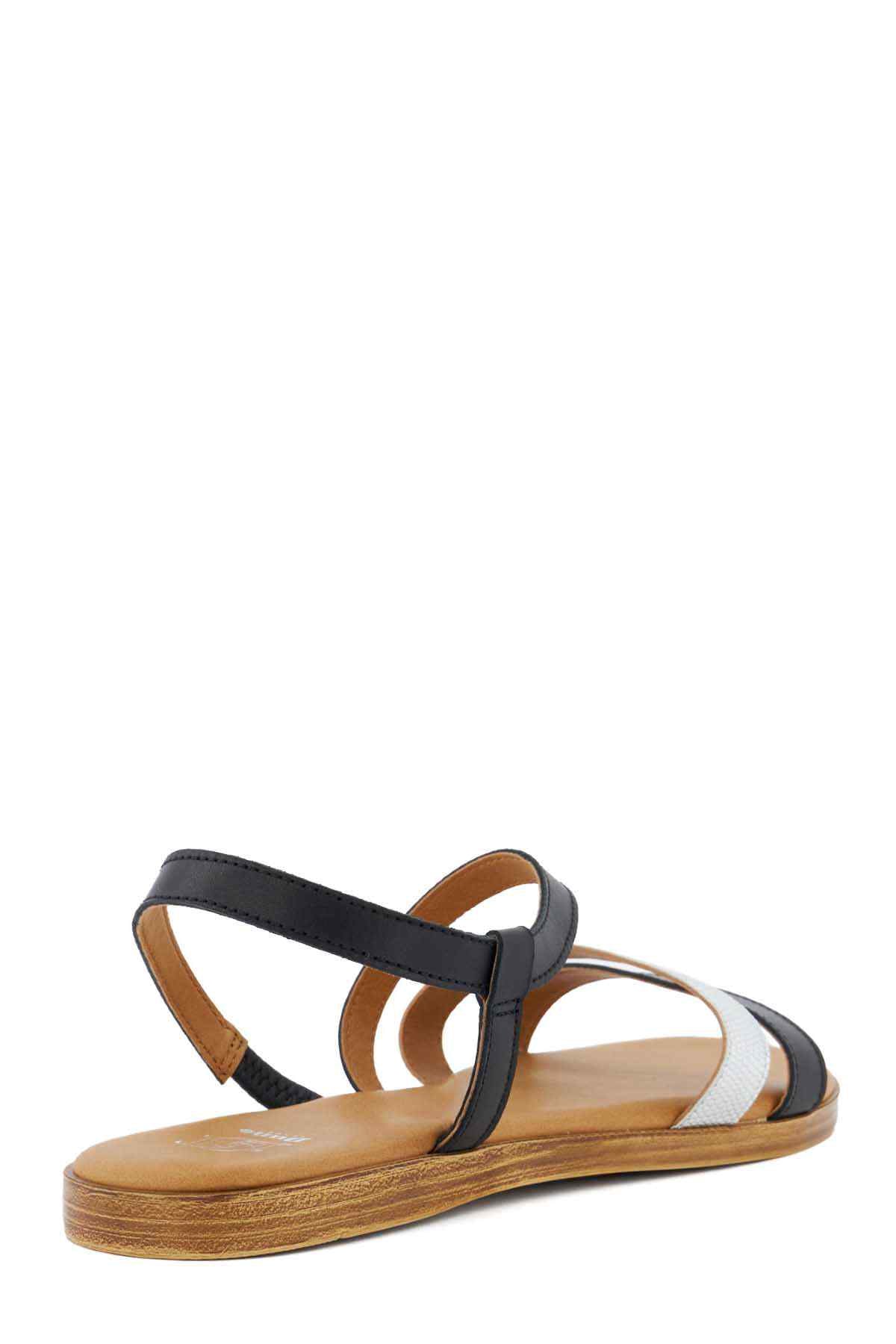 Black and white flat sandals with T-strap and tan textured sole