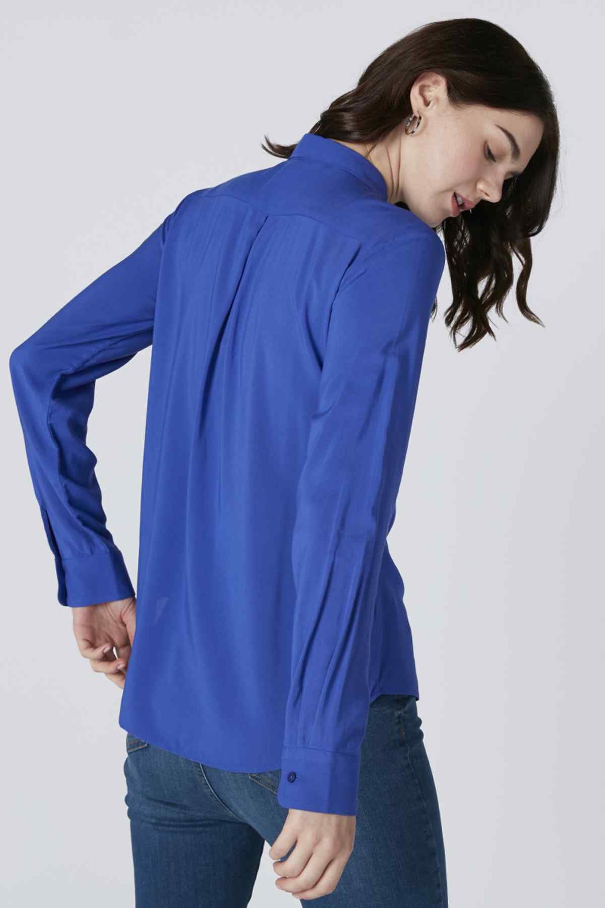 Blue button-up shirt showing the back with long sleeves and collared neckline