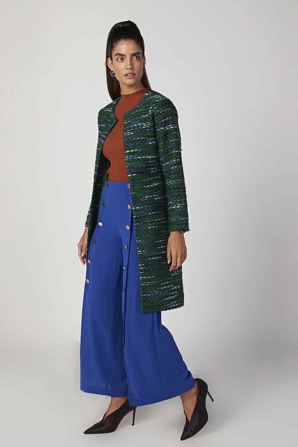 Orange ribbed sleeveless knit top peeking under green textured cardigan
