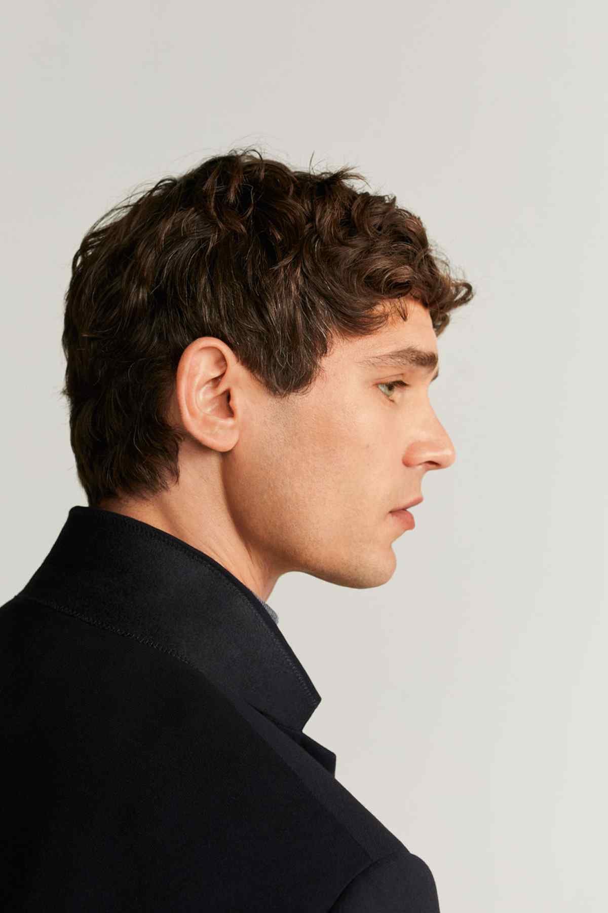 Men's black suit jacket collar and lapel detail with buttoned neckline