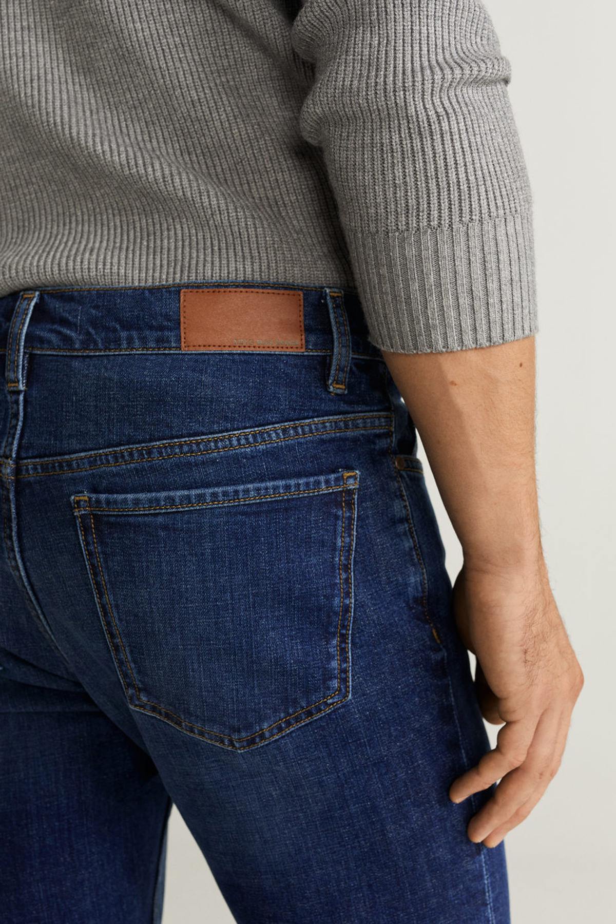 Men's dark blue denim jeans back pocket with leather patch and contrast stitching