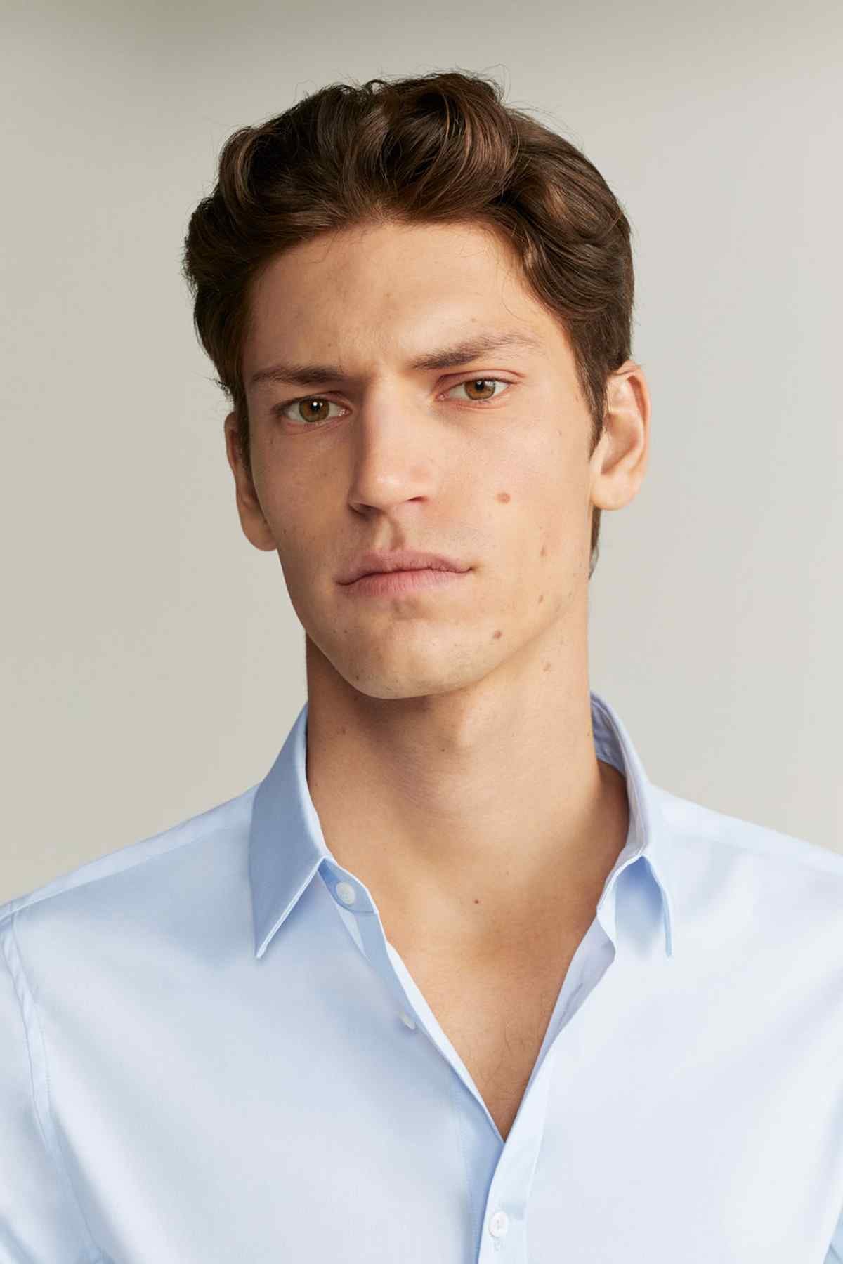 Men's light blue dress shirt close-up of spread collar and button placket