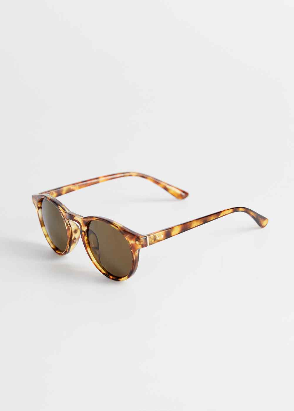 Cognac tortoiseshell oval sunglasses with dark lenses, angled view