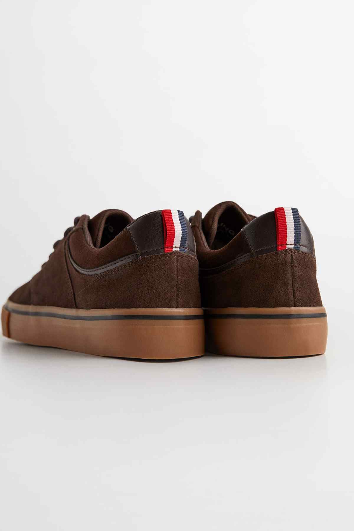 Brown suede sneakers with heel tab, gum sole, and red/white/blue stripe detail