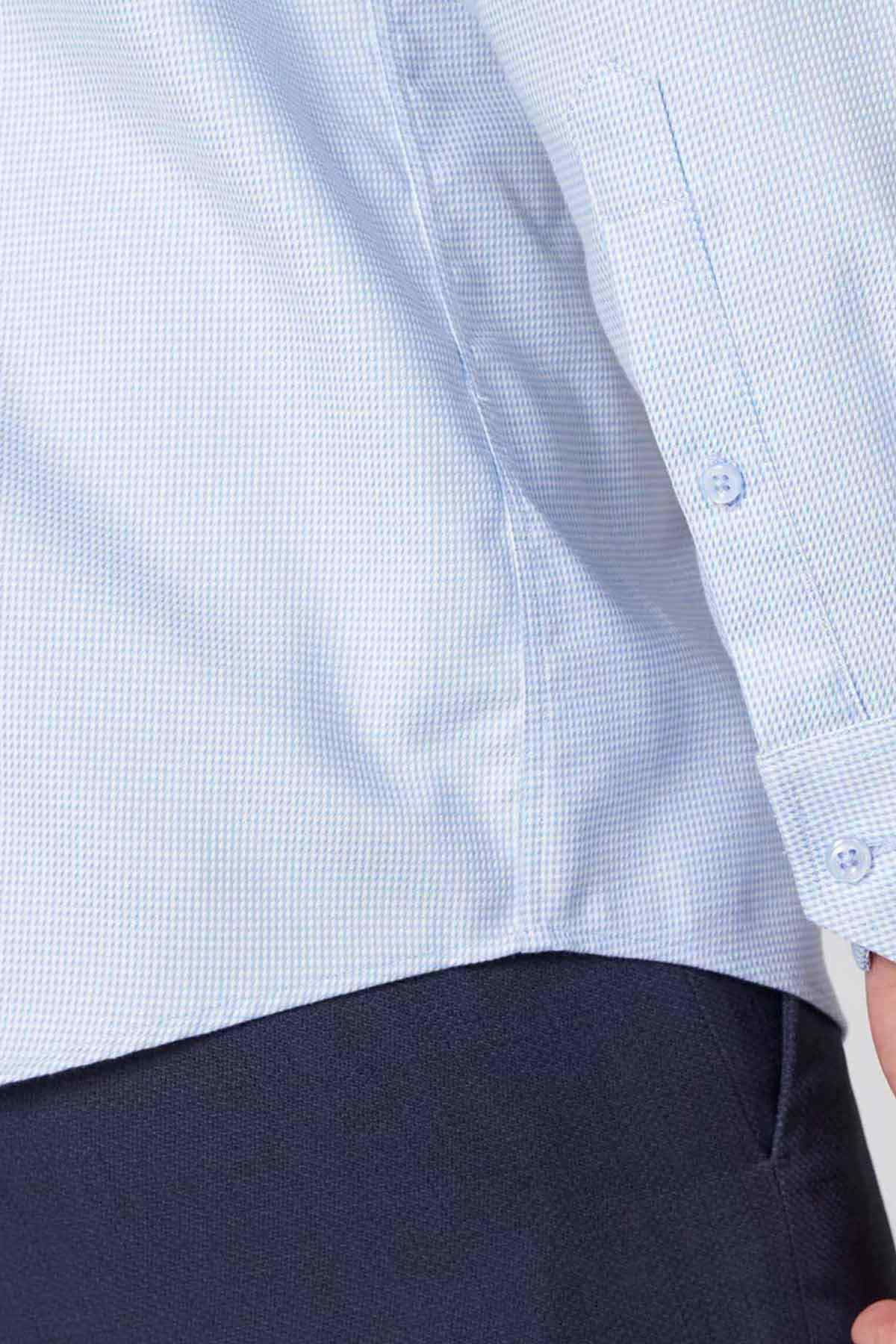 Light blue dress shirt cuff and sleeve with subtle texture, button detail
