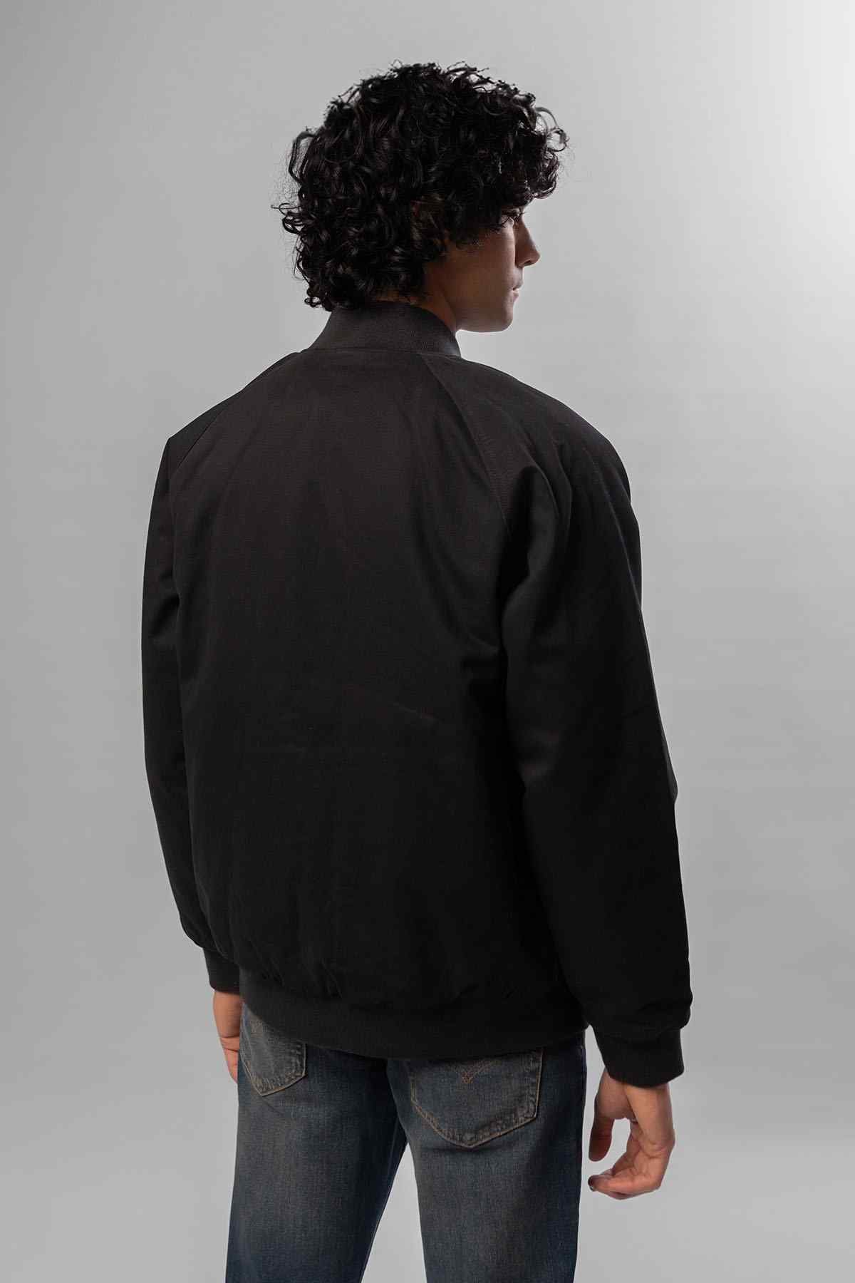 Black bomber jacket back view with ribbed hem and cuffs