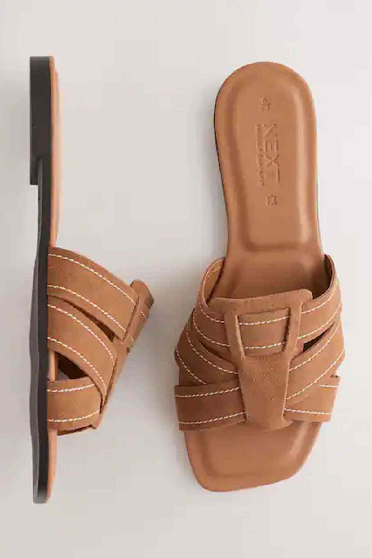 Tan brown slide sandals showing outsole side and embossed footbed text
