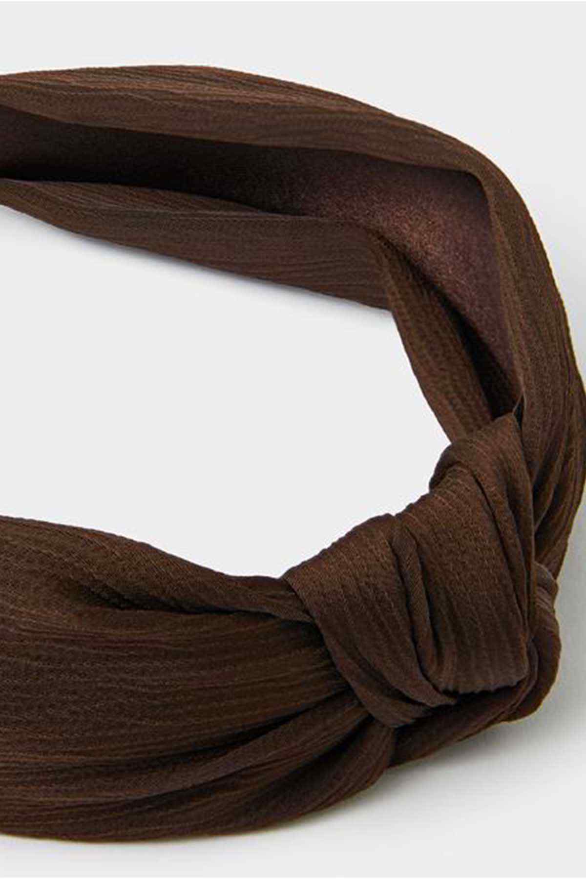 Dark brown twisted headband detail, knotted fabric loop