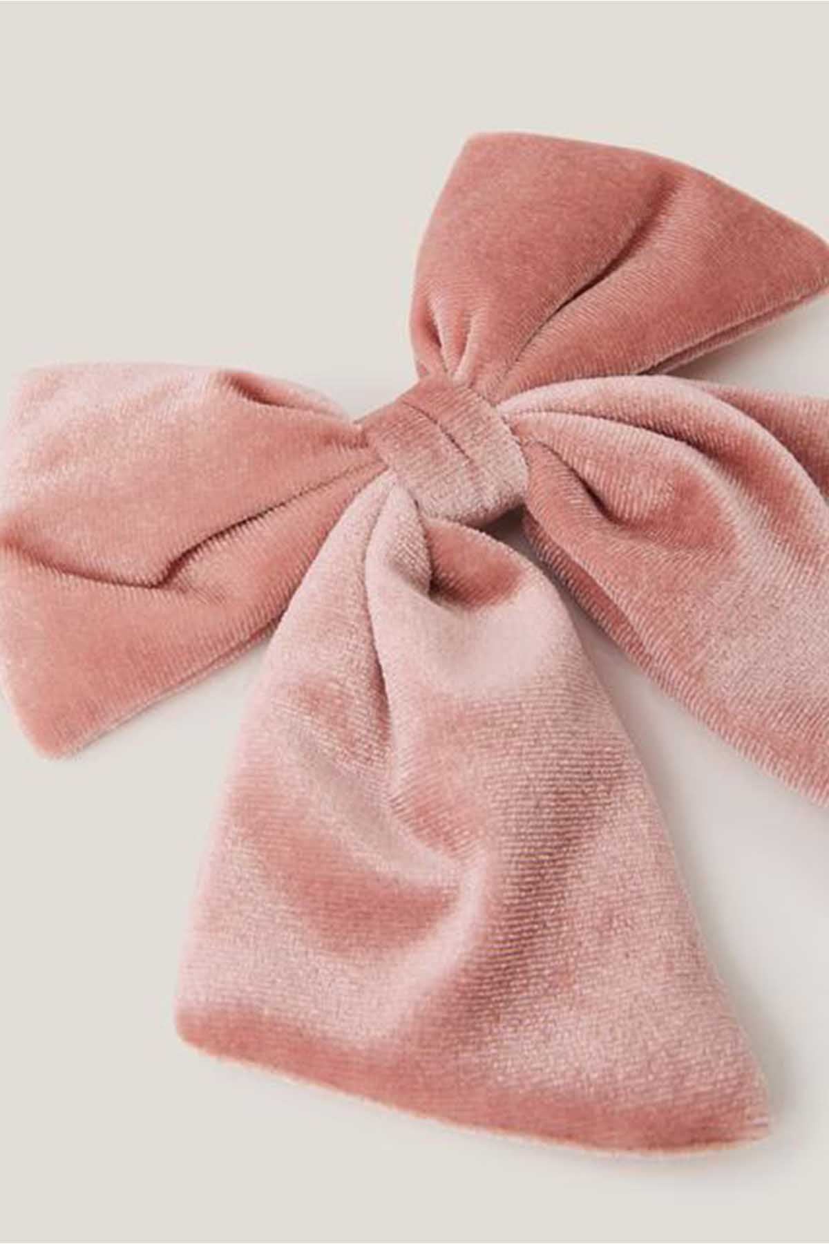 Pink fabric bow hair accessory close-up with tied knot and layered loops