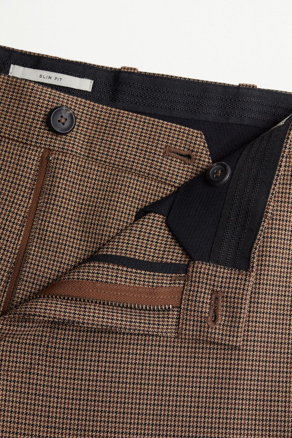 Houndstooth check trouser waistband with button closure and inner waistband detail