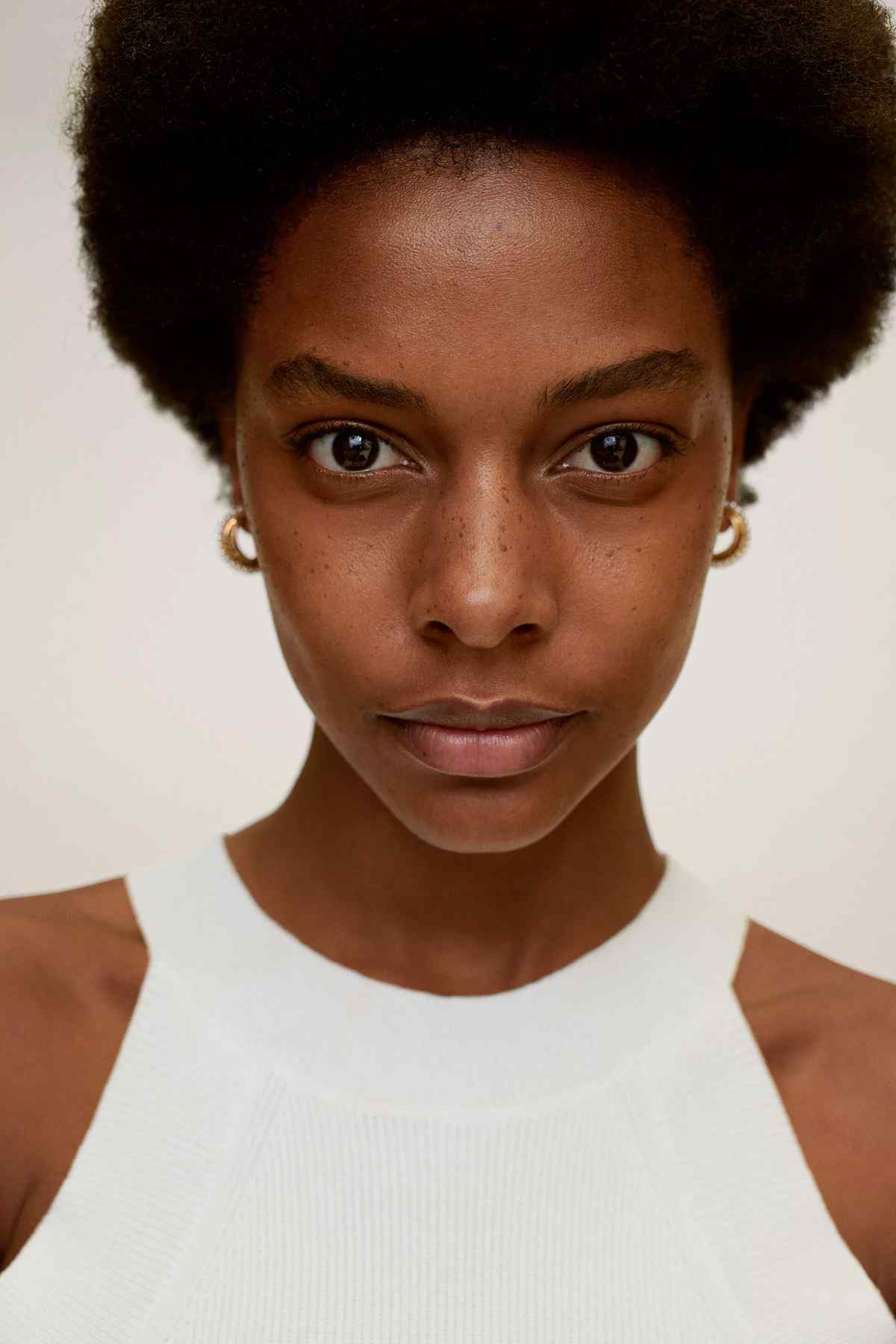 Gold hoop earrings with pearl bead detail worn by model