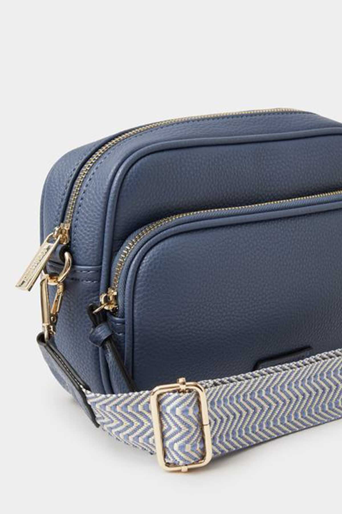Blue crossbody bag with chevron lining, front zip pocket, gold hardware