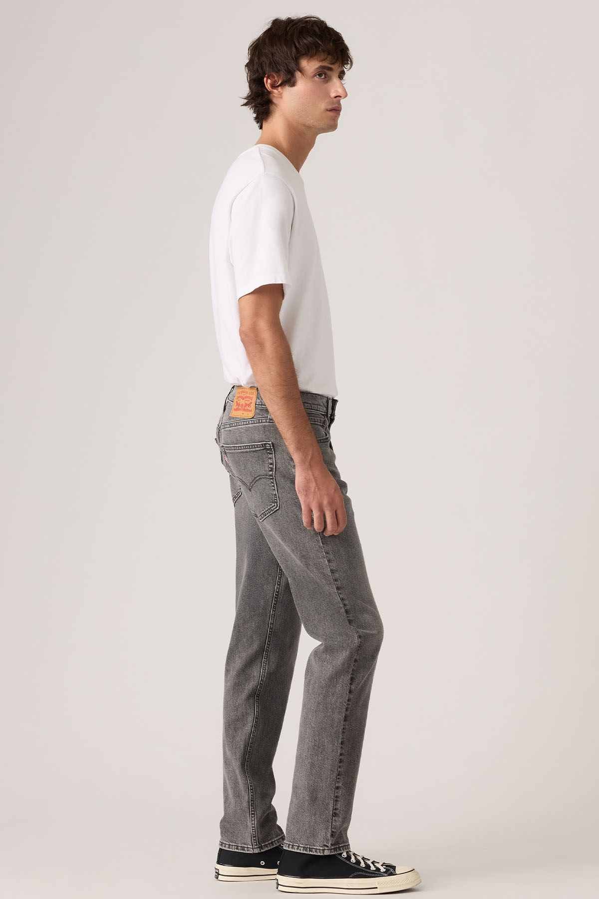 Grey denim jeans with straight legs and orange patch on the pocket