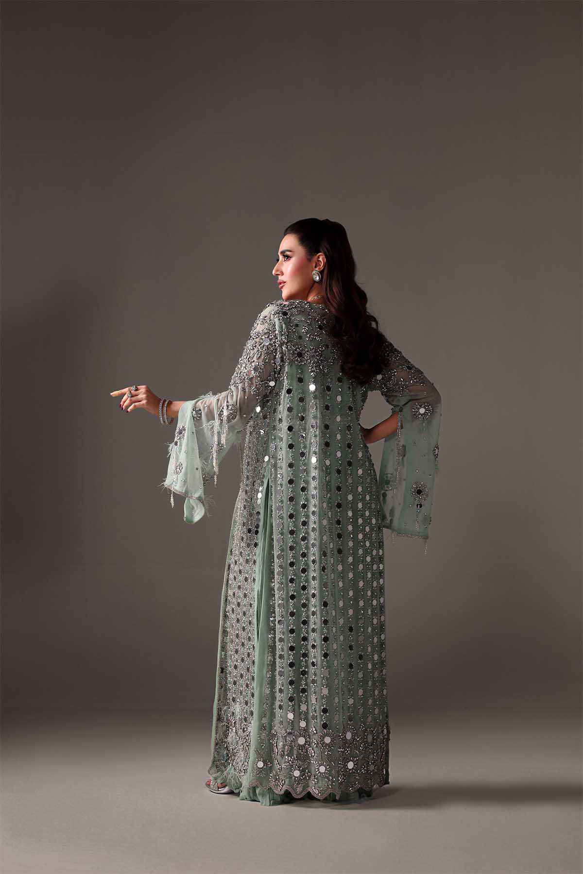 Light green embellished maxi dress with long sleeves, beaded motifs, and flowing drape