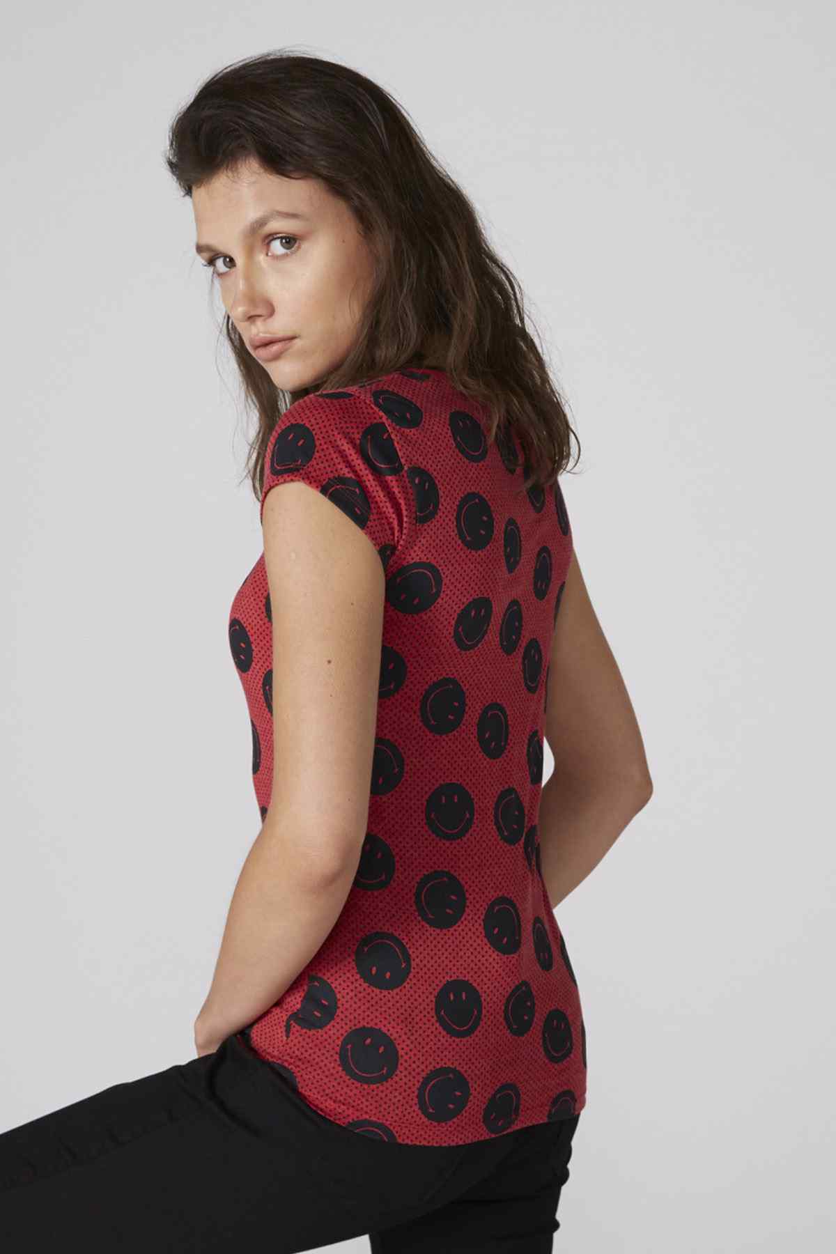 Red short-sleeve crew-neck T-shirt with black smiley face print, side view