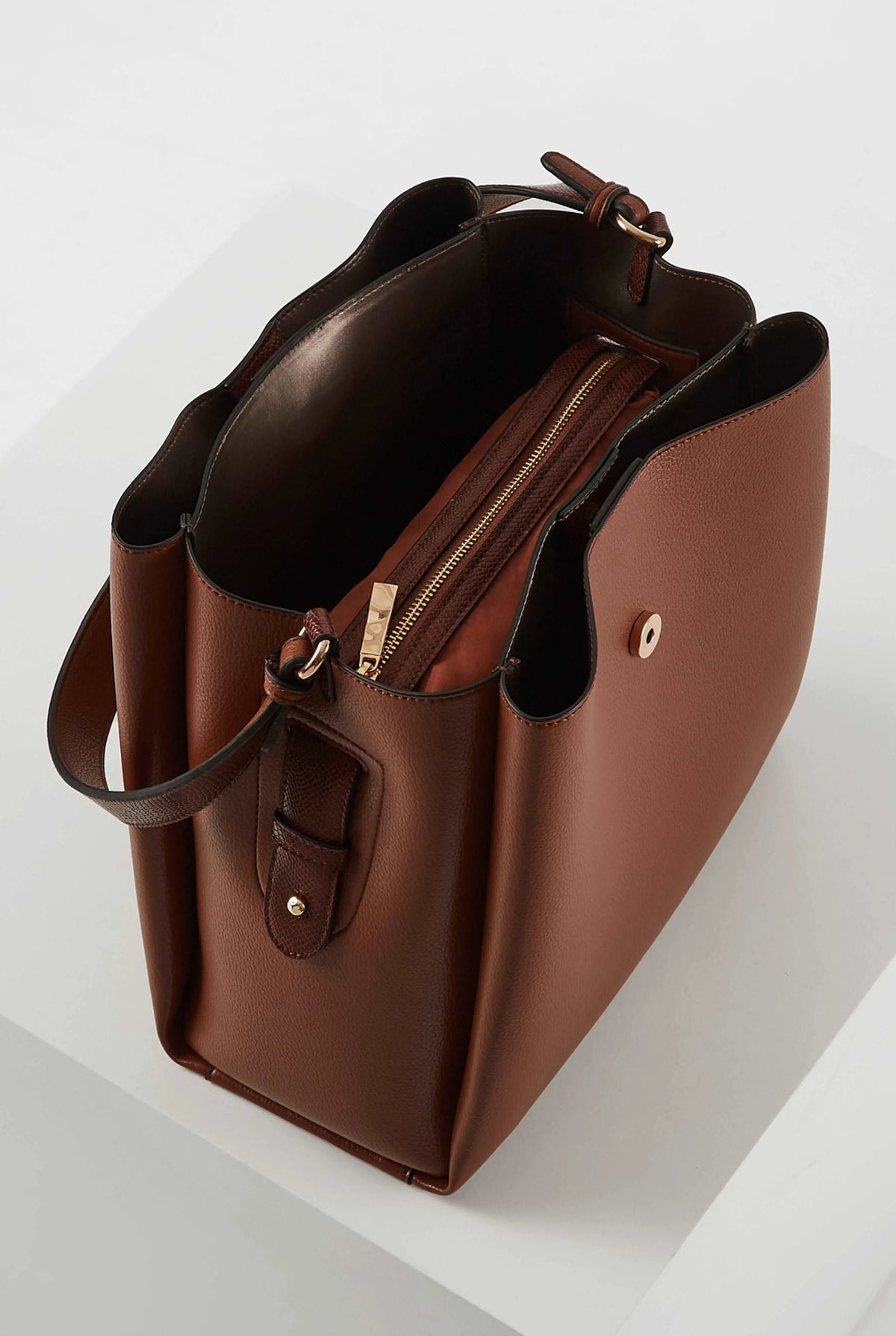 Brown leather handbag with open top and double zippers, front slip pocket