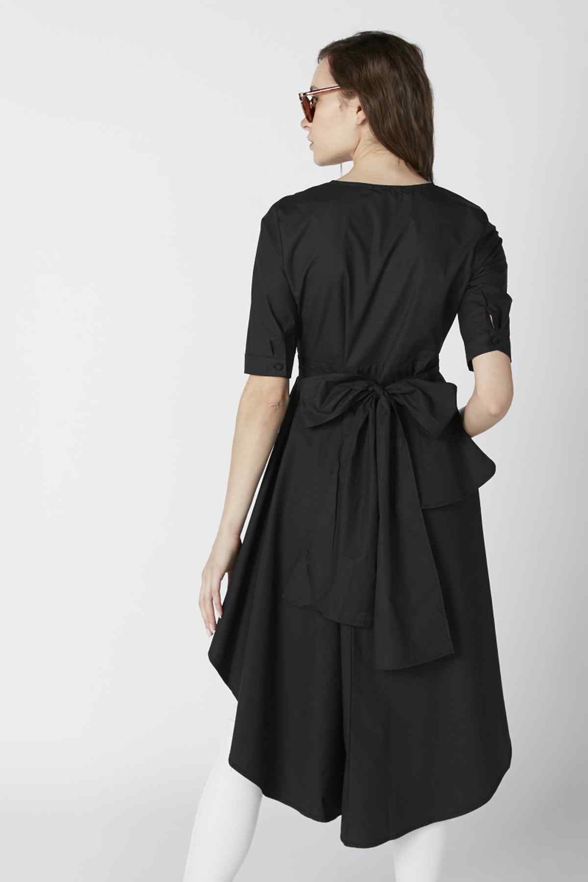 Back view of black belted tunic dress with tie waist and flowing curved hem