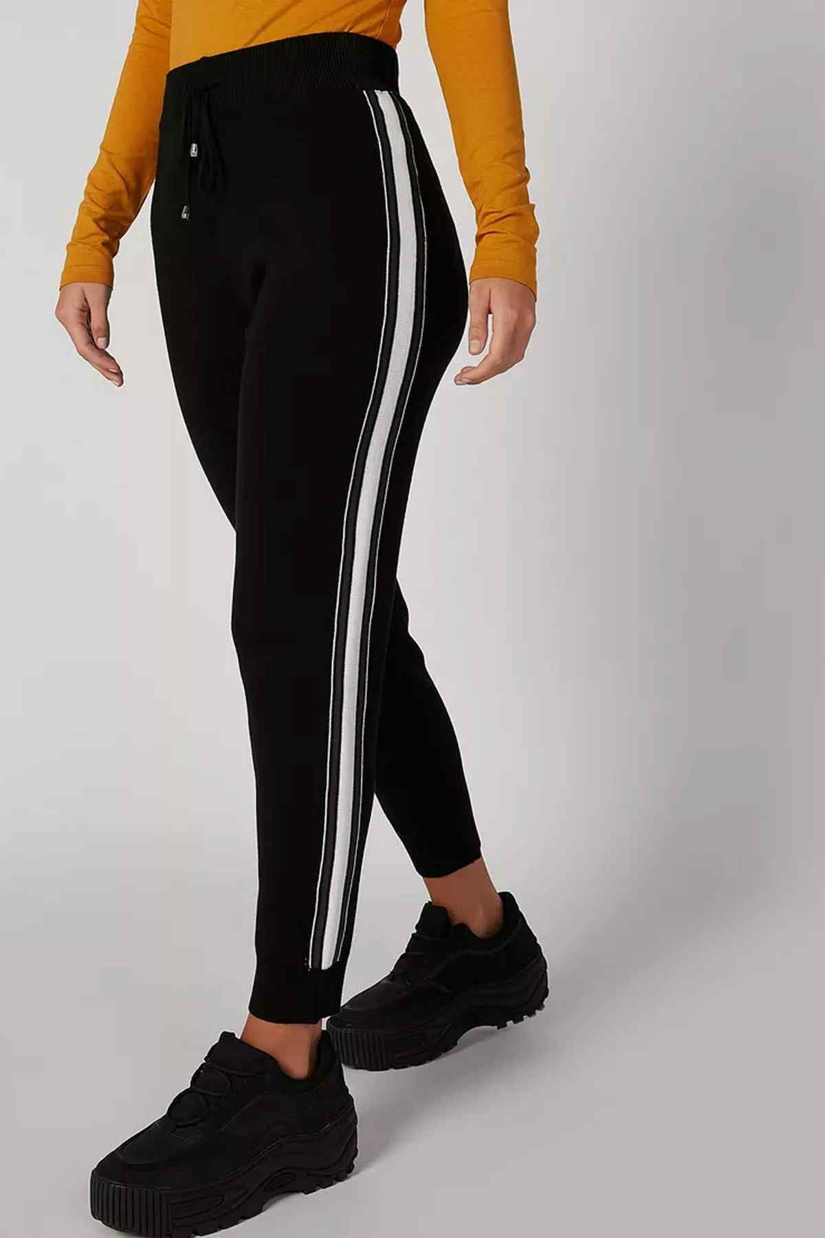 Black fitted track pants with white side stripe and back seam detailing