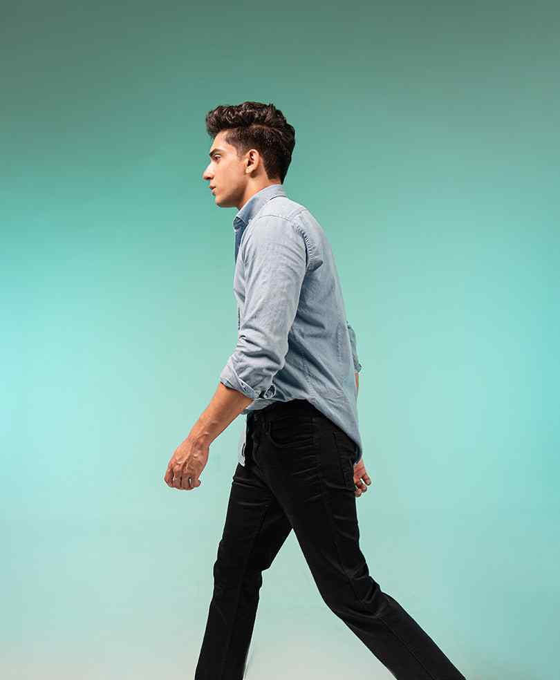 Fitted light blue button-up shirt in side profile with long sleeves and buttons