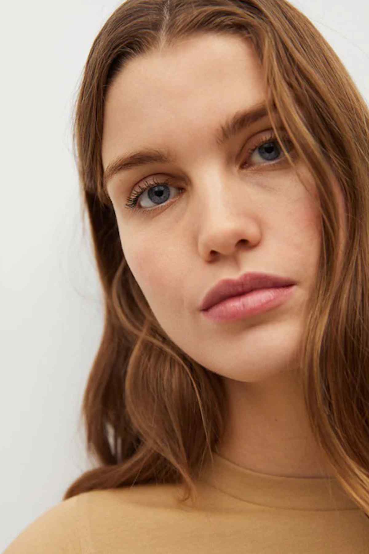 Beige crew-neck top with short sleeves, close-up of neckline